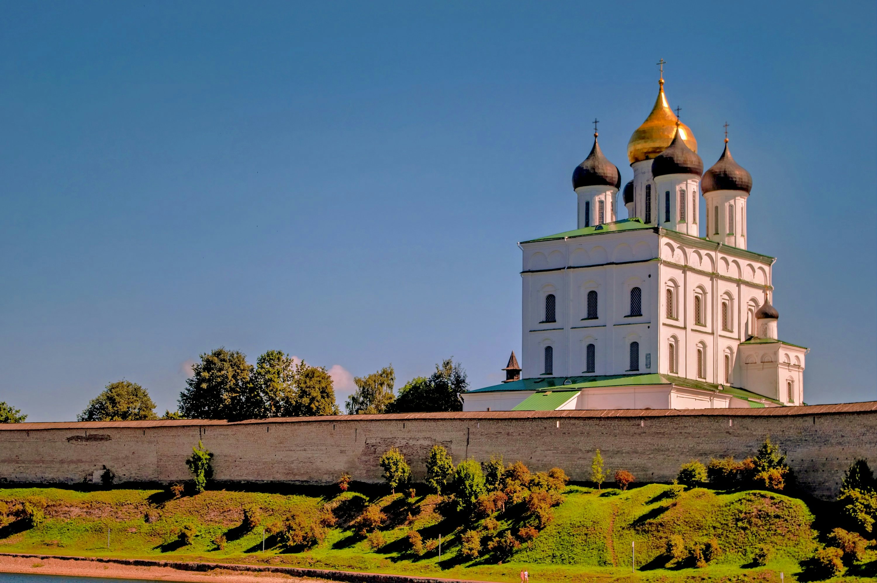 A white church with golden domes is pictured.