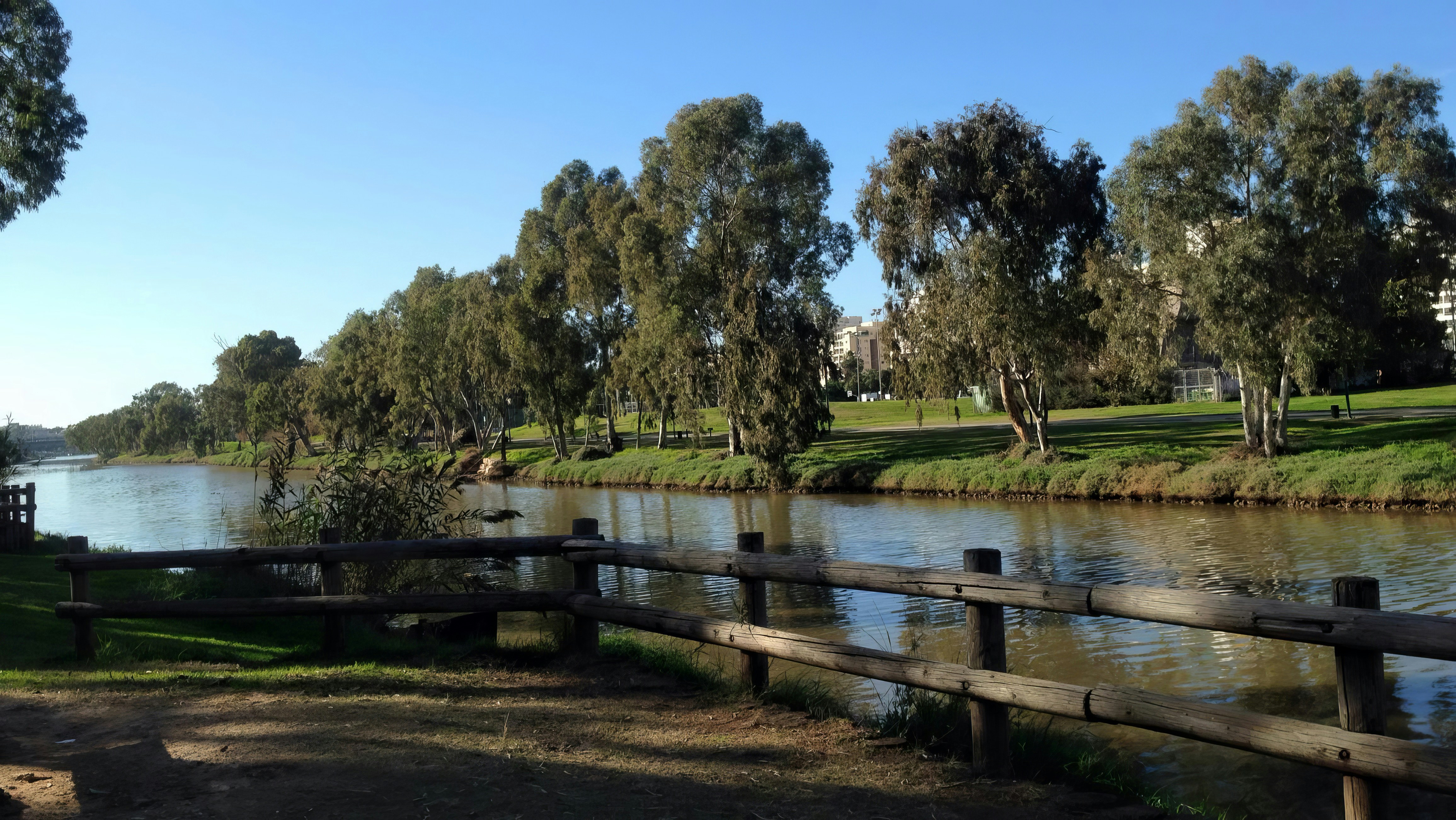 A river flows along green trees.