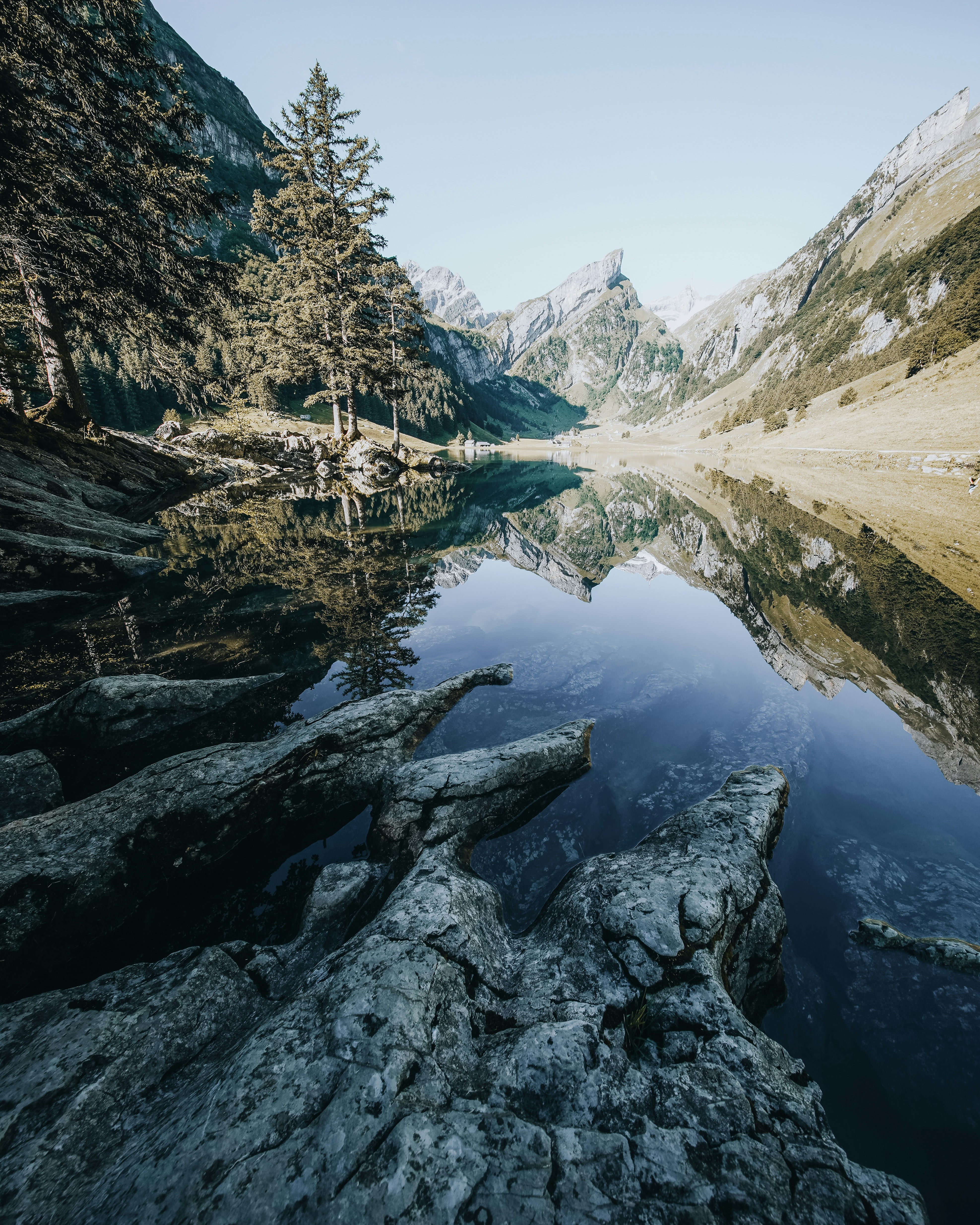 A calm lake reflects mountains and trees.