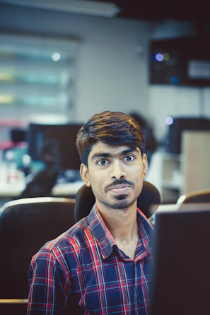 Man is in office, looking at the camera.