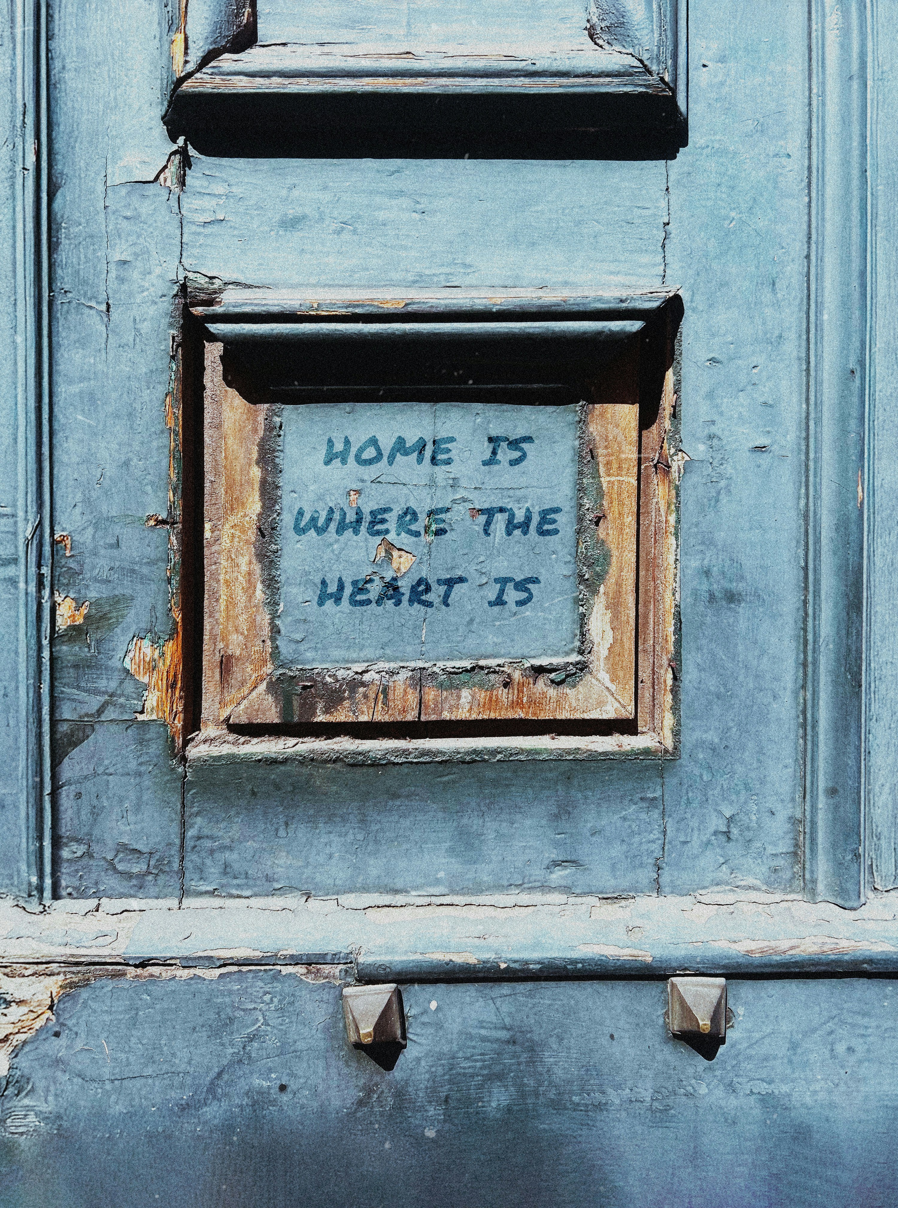 Old wooden door with "home is where the heart is".