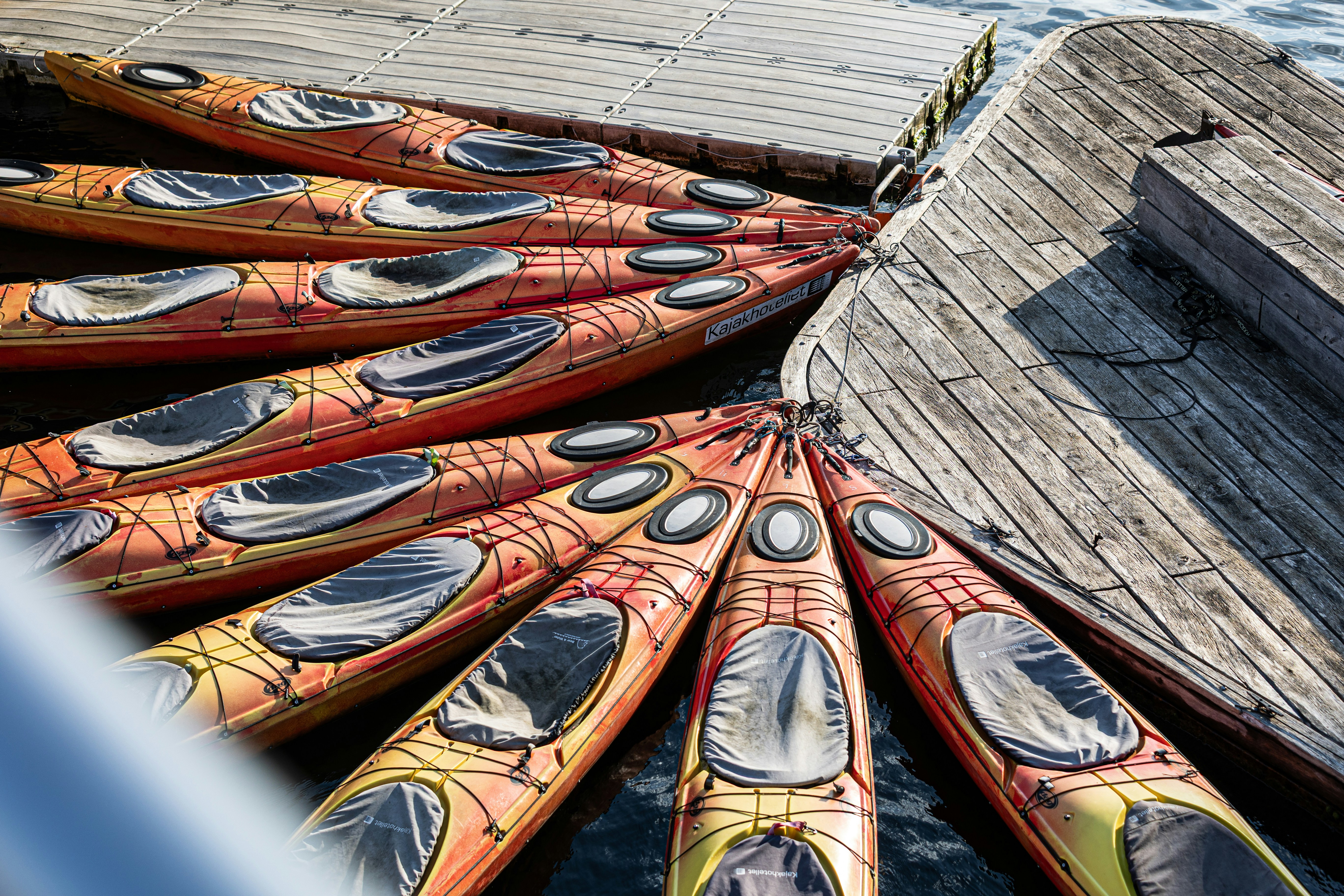 Kayaks are lined up on the wooden dock.