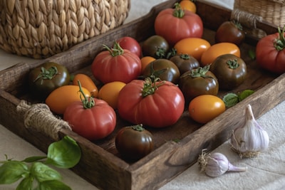Tomatoes and garlic arranged on a wooden tray.