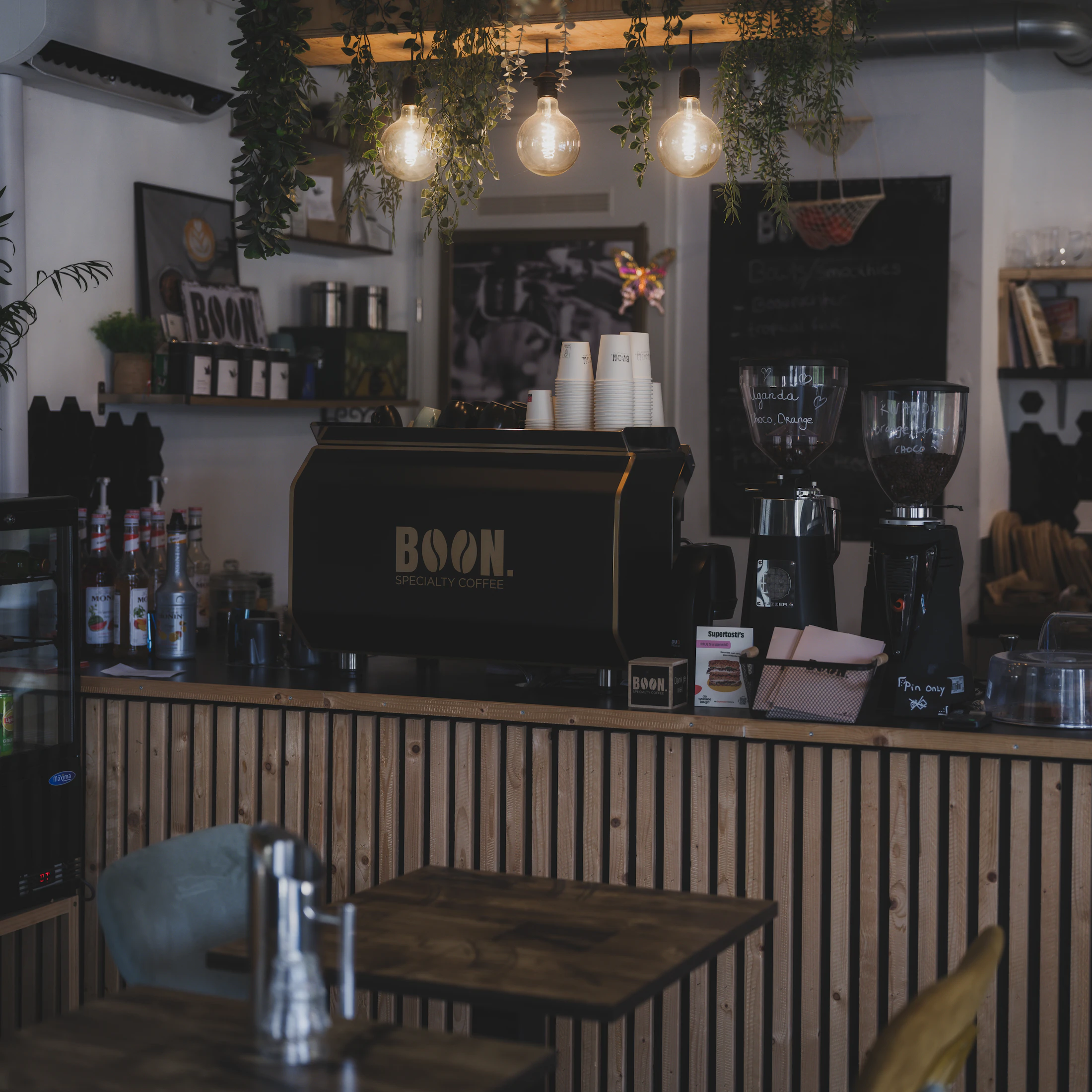 Oak tables and warm light in the quieter half of the cafe
