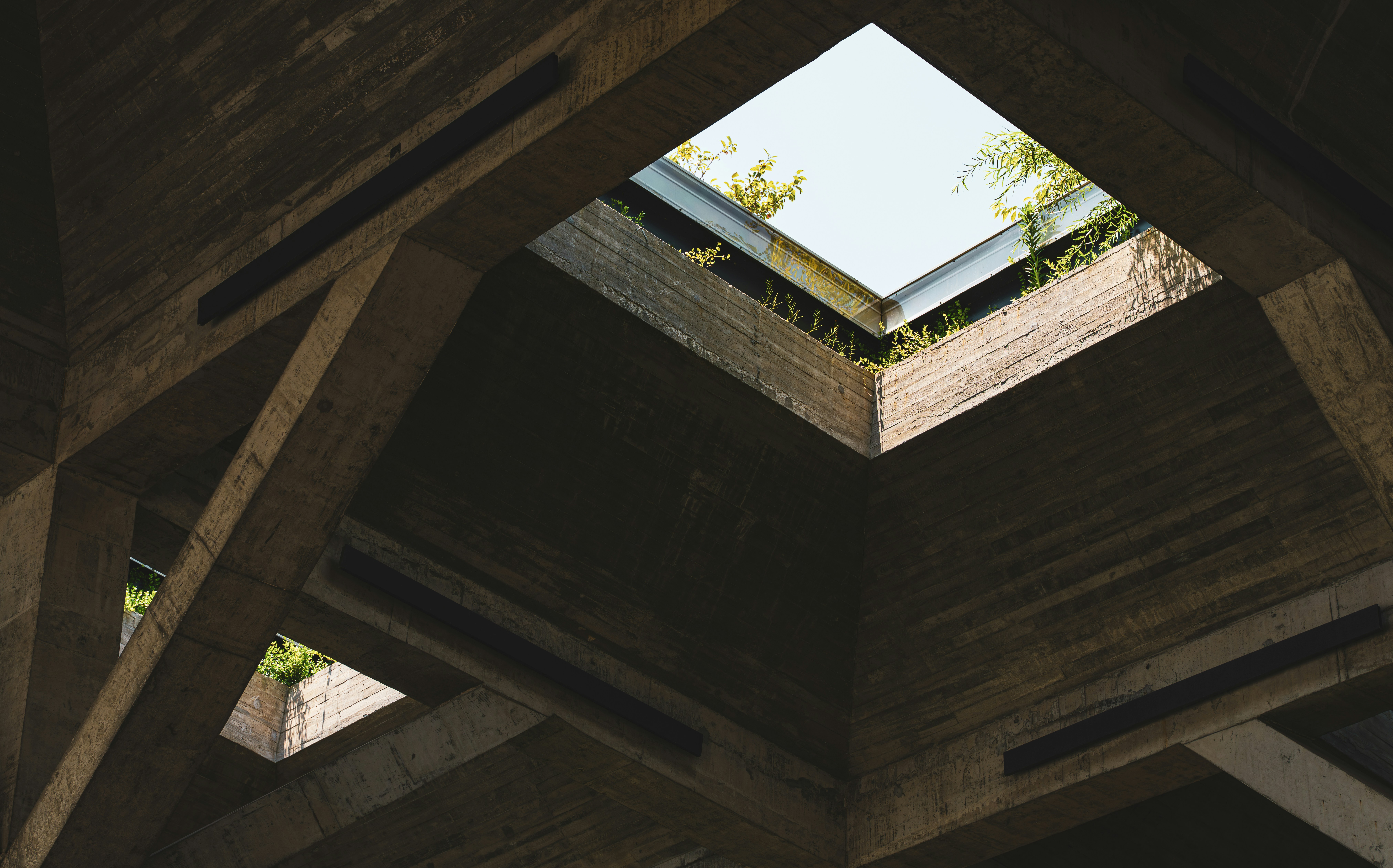 Concrete ceiling with a square opening to the sky.