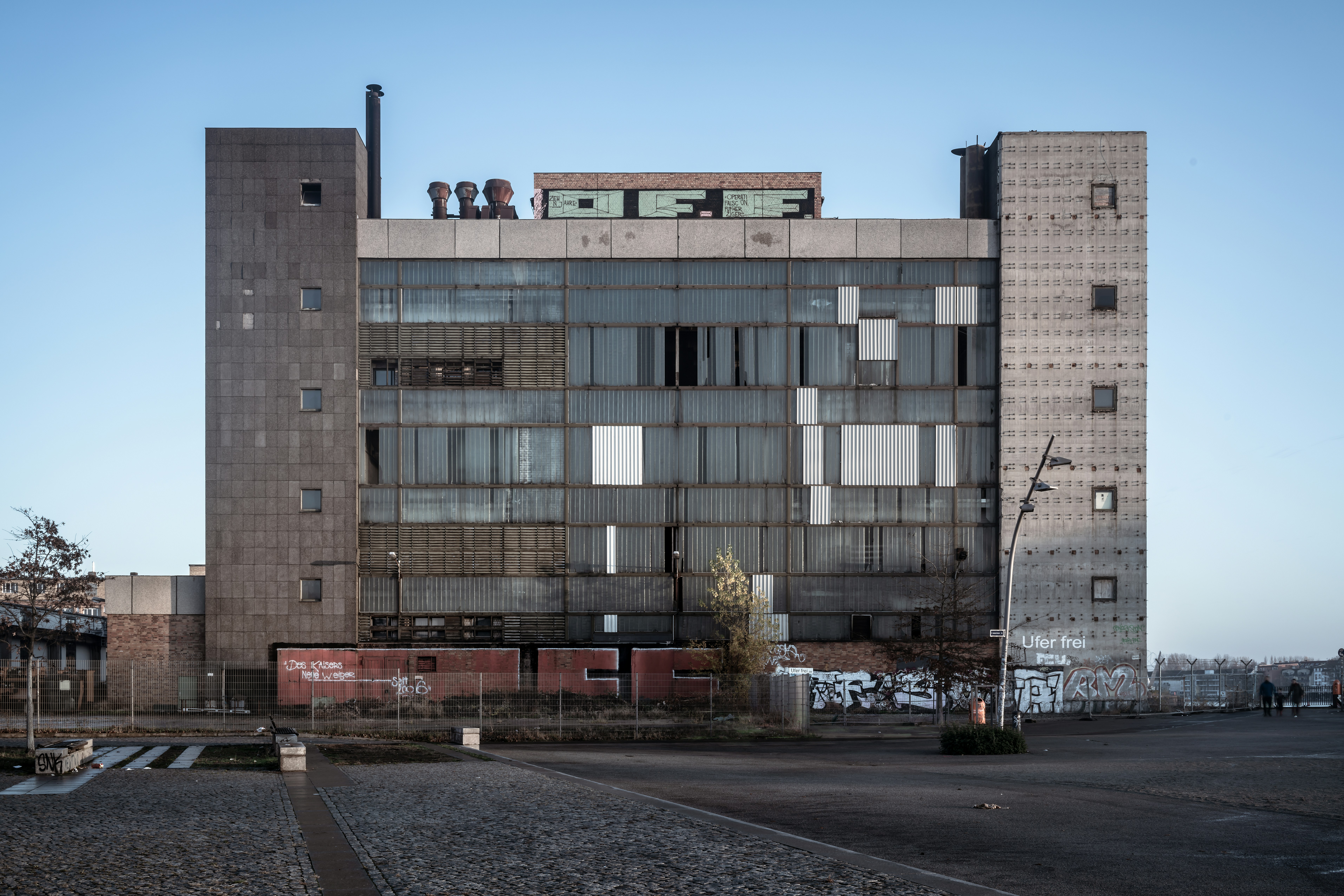 Abandoned concrete building stands against a clear sky.