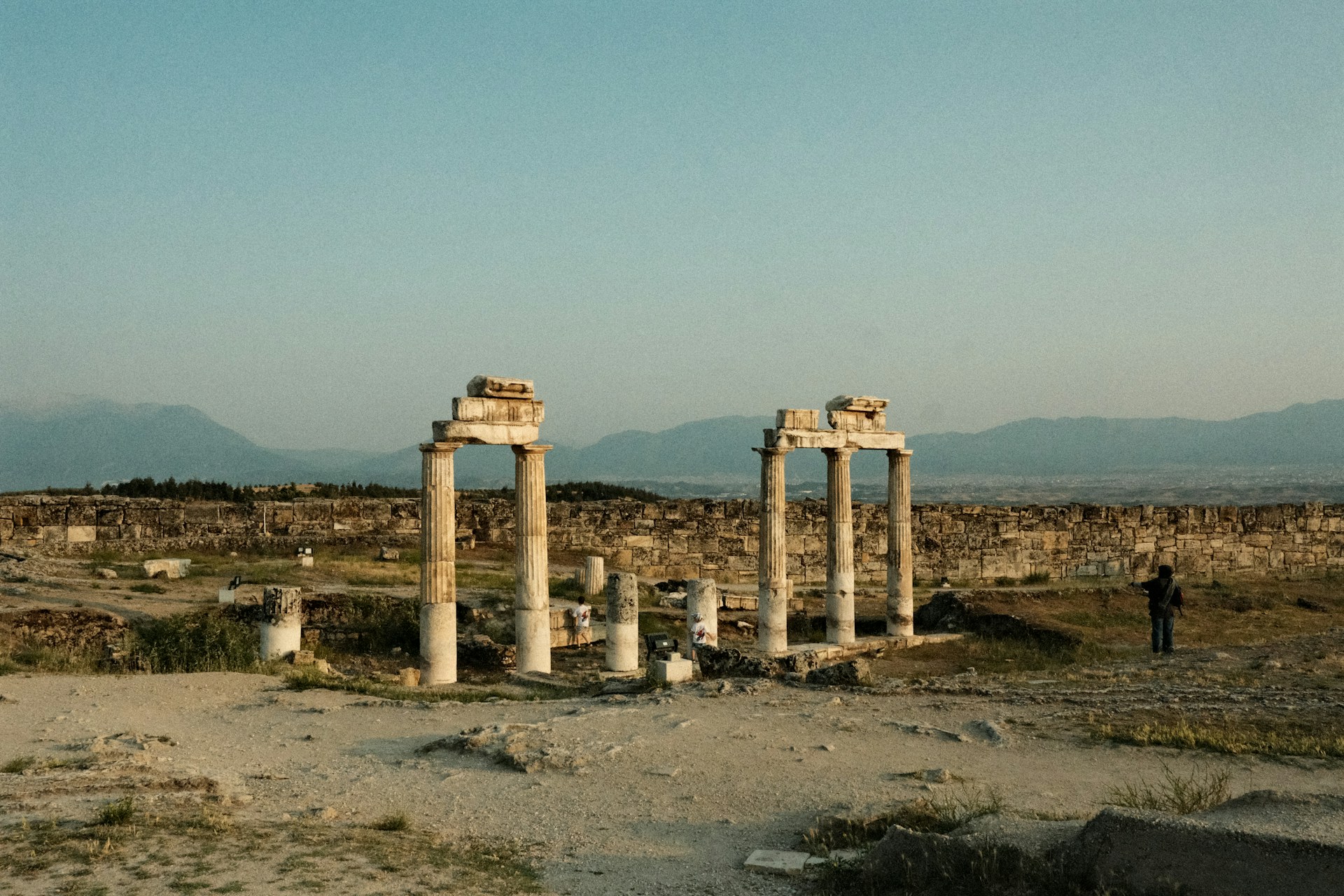 Ancient ruins stand against a serene, clear sky.
