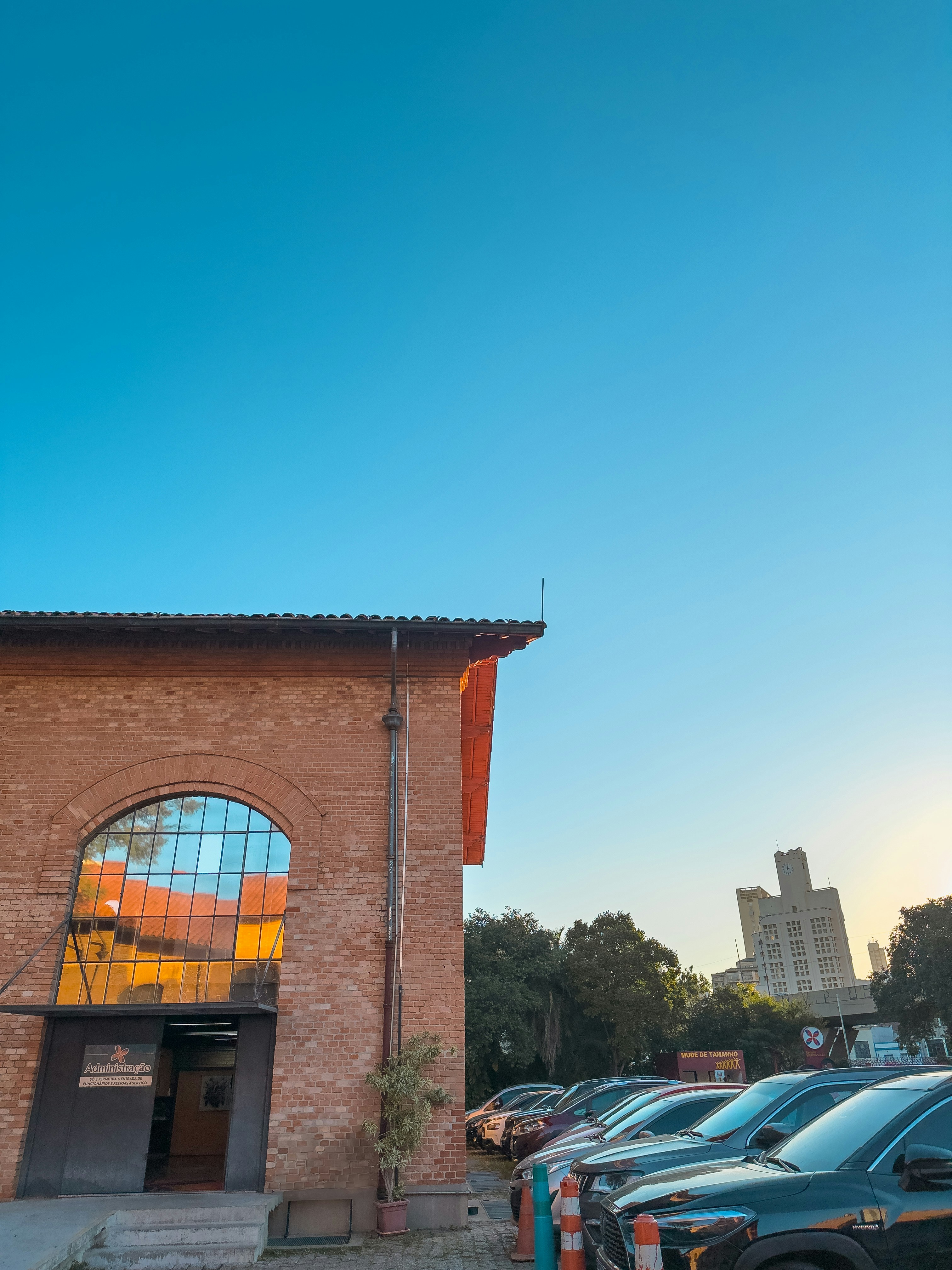 Brick building, cars, and a clear blue sky.