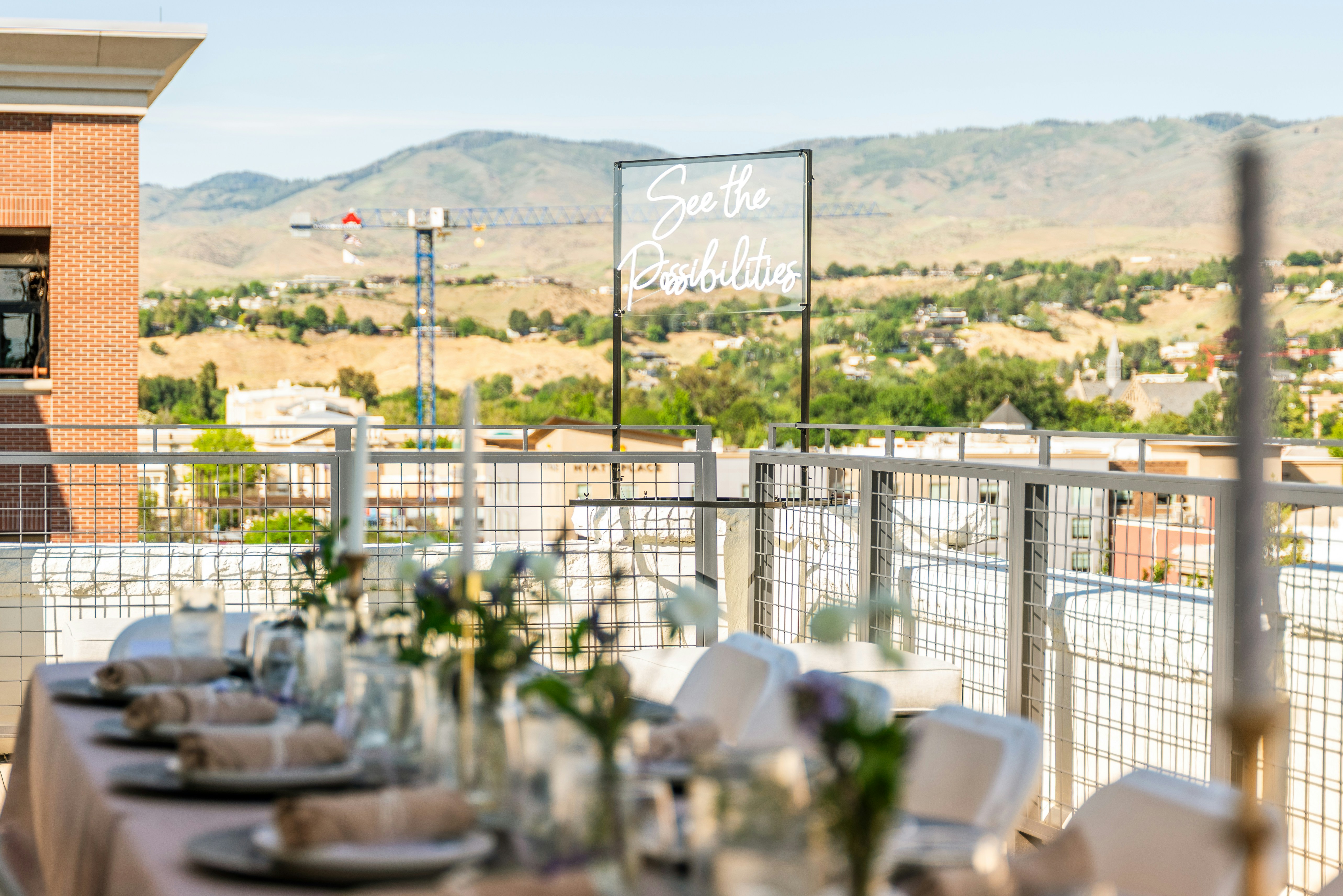 Rooftop table set up with a sign and scenery.