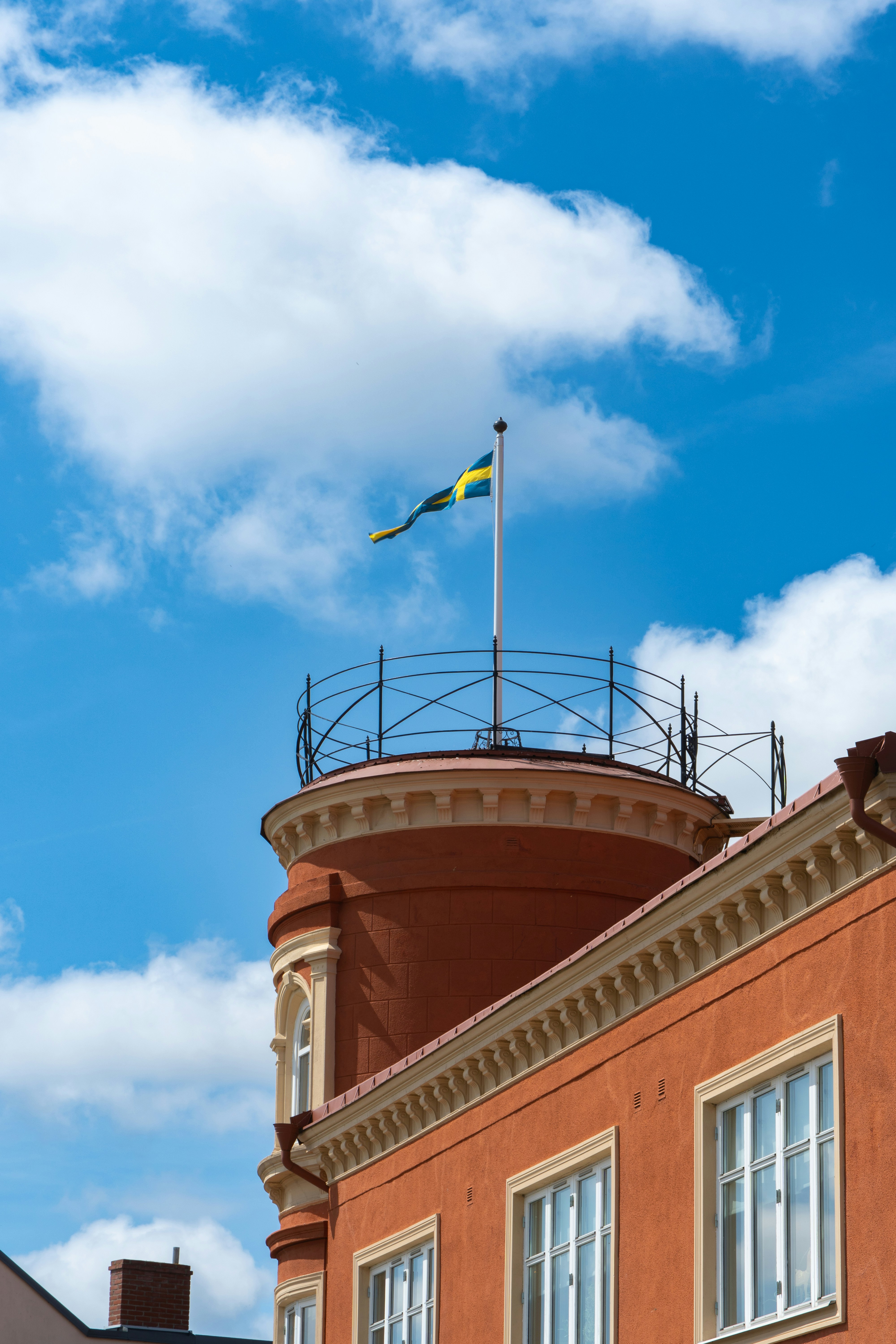 Swedish flag waves atop a building.