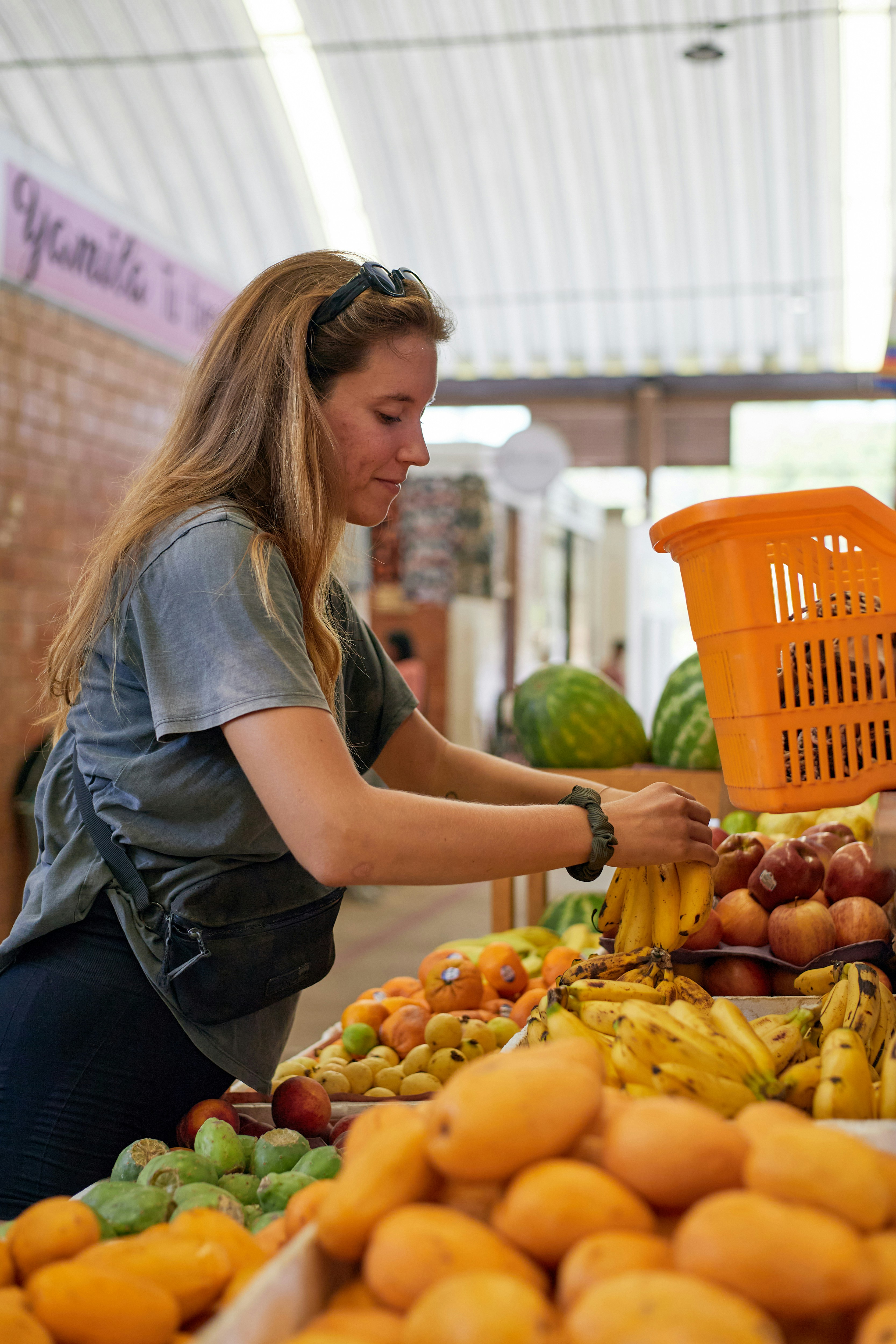 Woman shops for fresh fruits at a market.