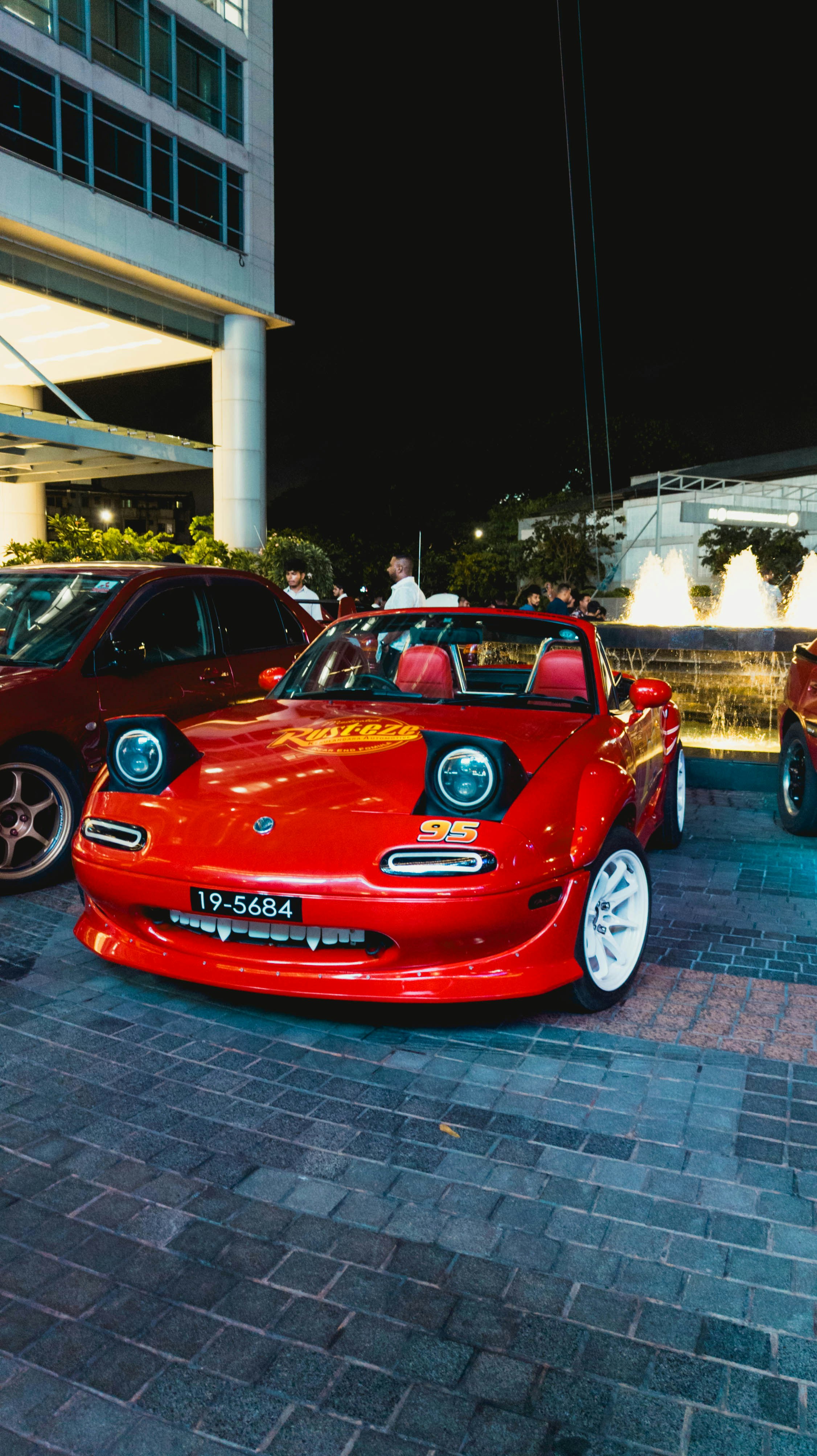 A red mazda miata with modified details.