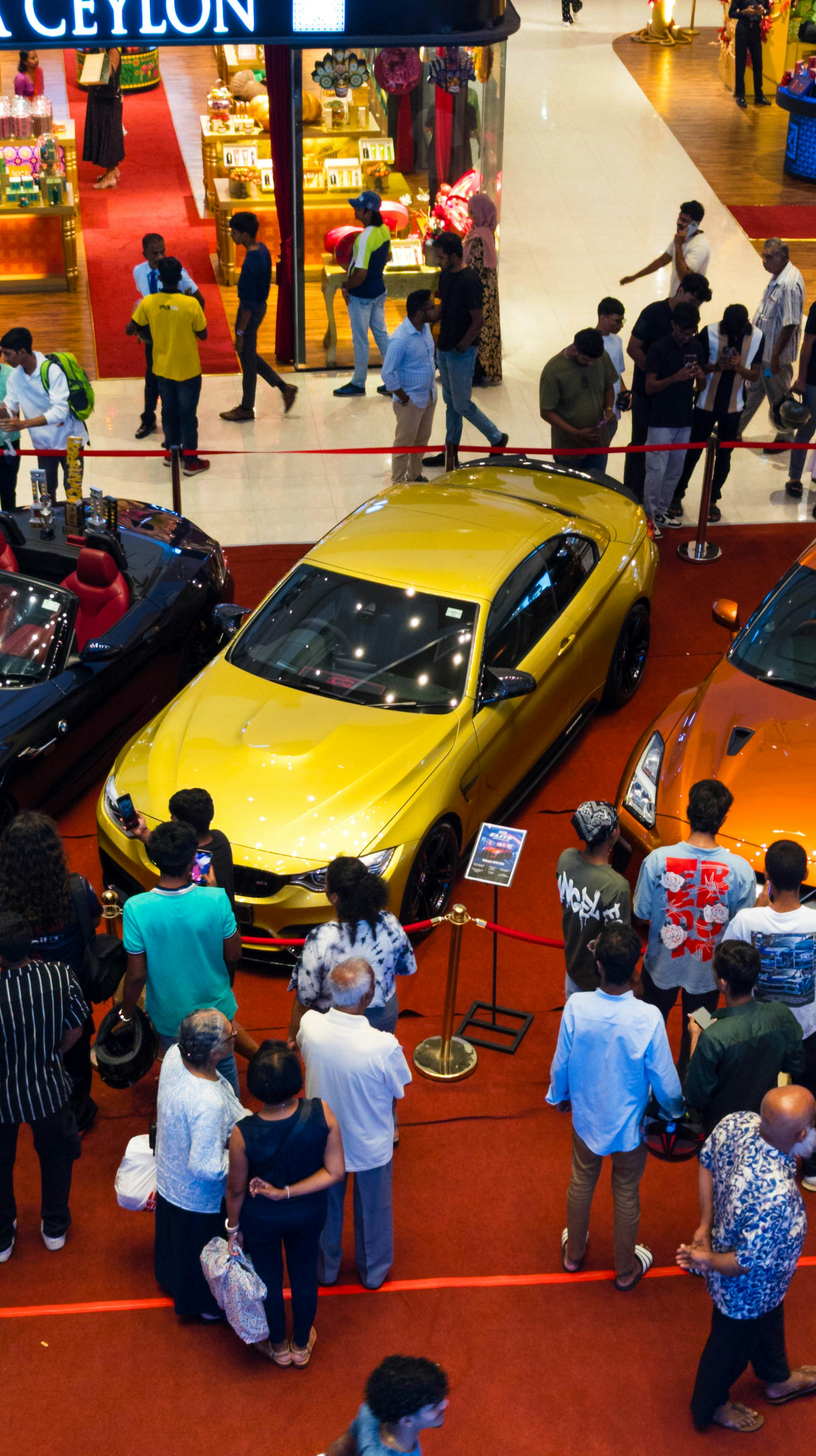People are gathered to look at the cars.
