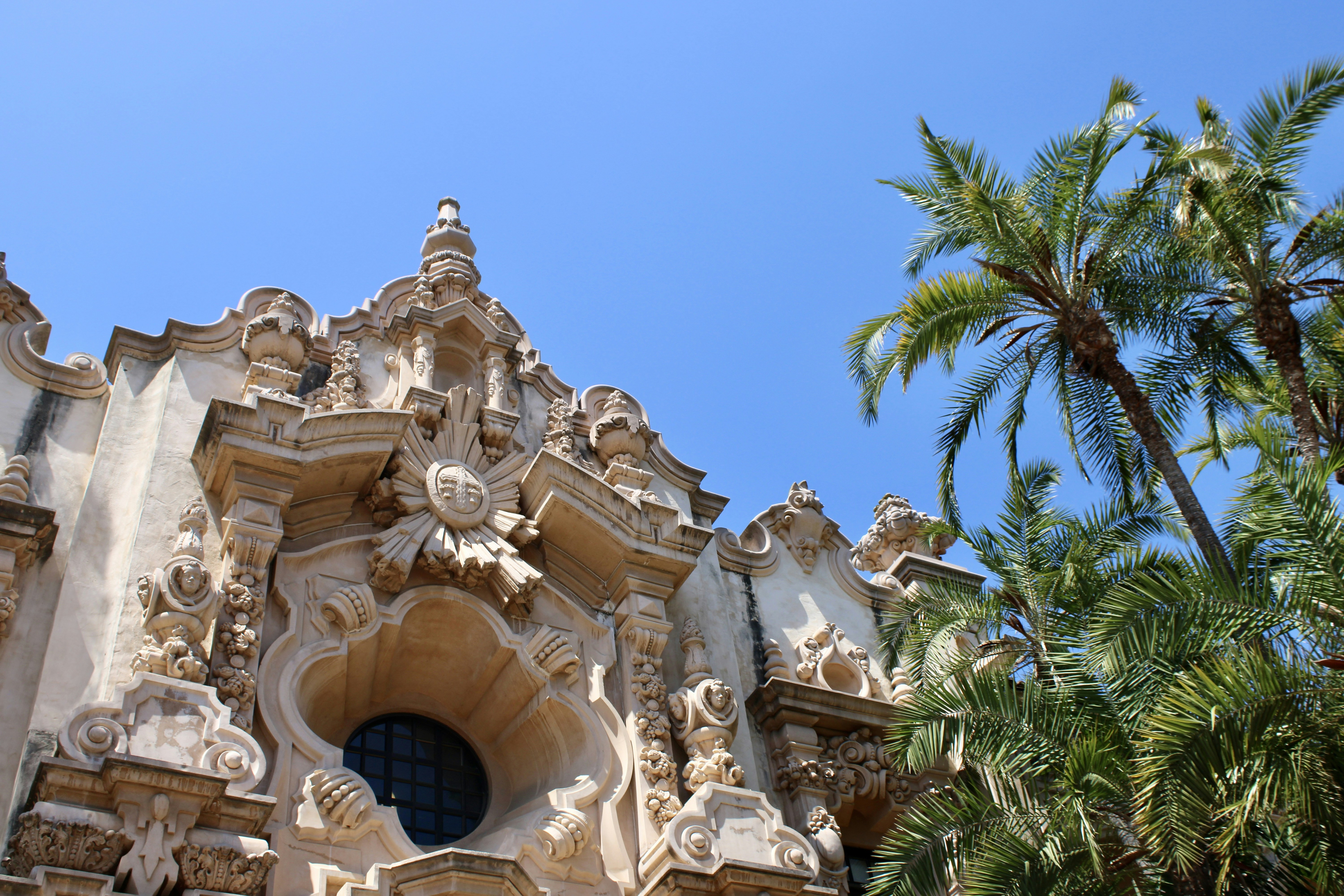 Ornate building with palms and a clear blue sky.