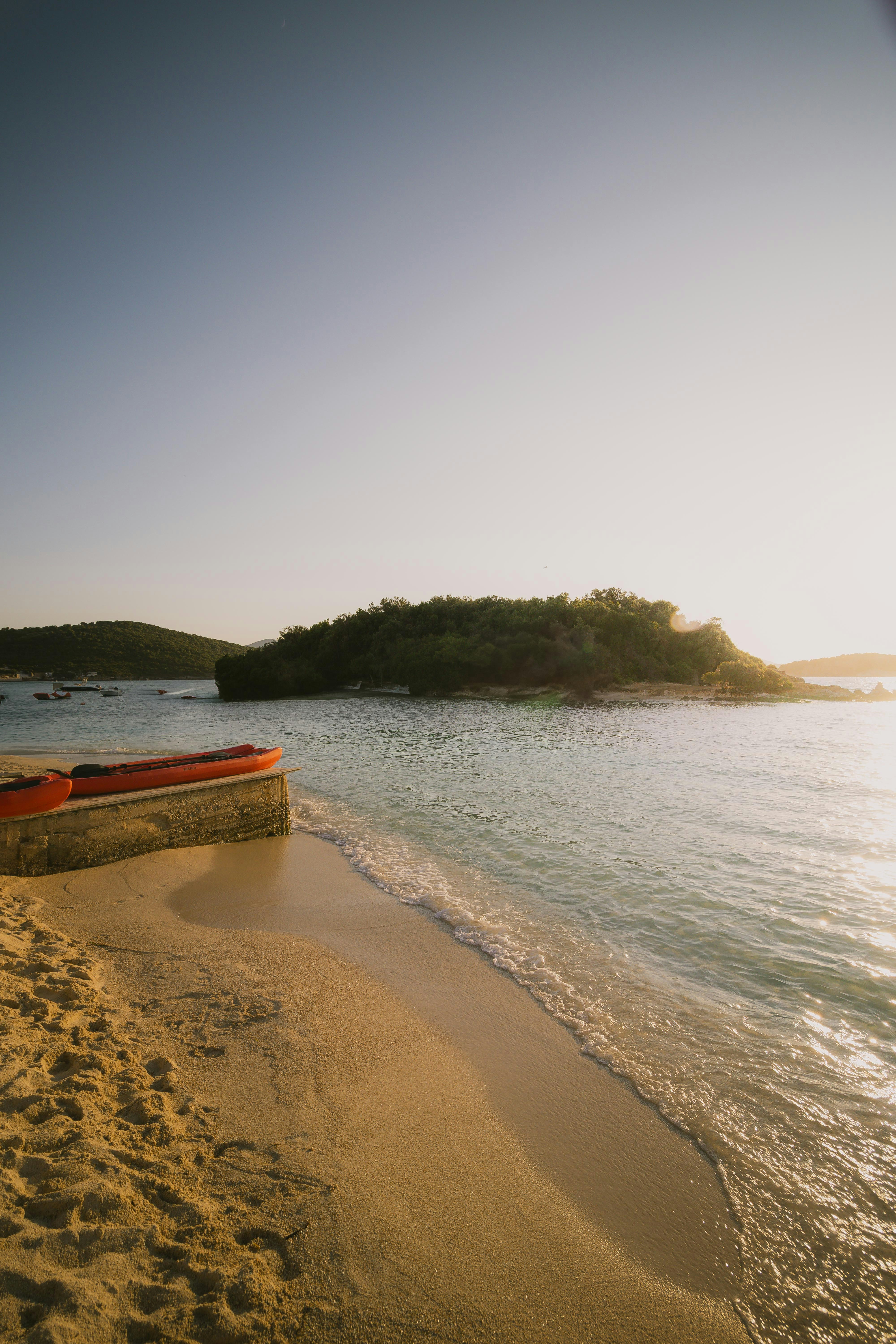 Escena de playa e isla con un barco.