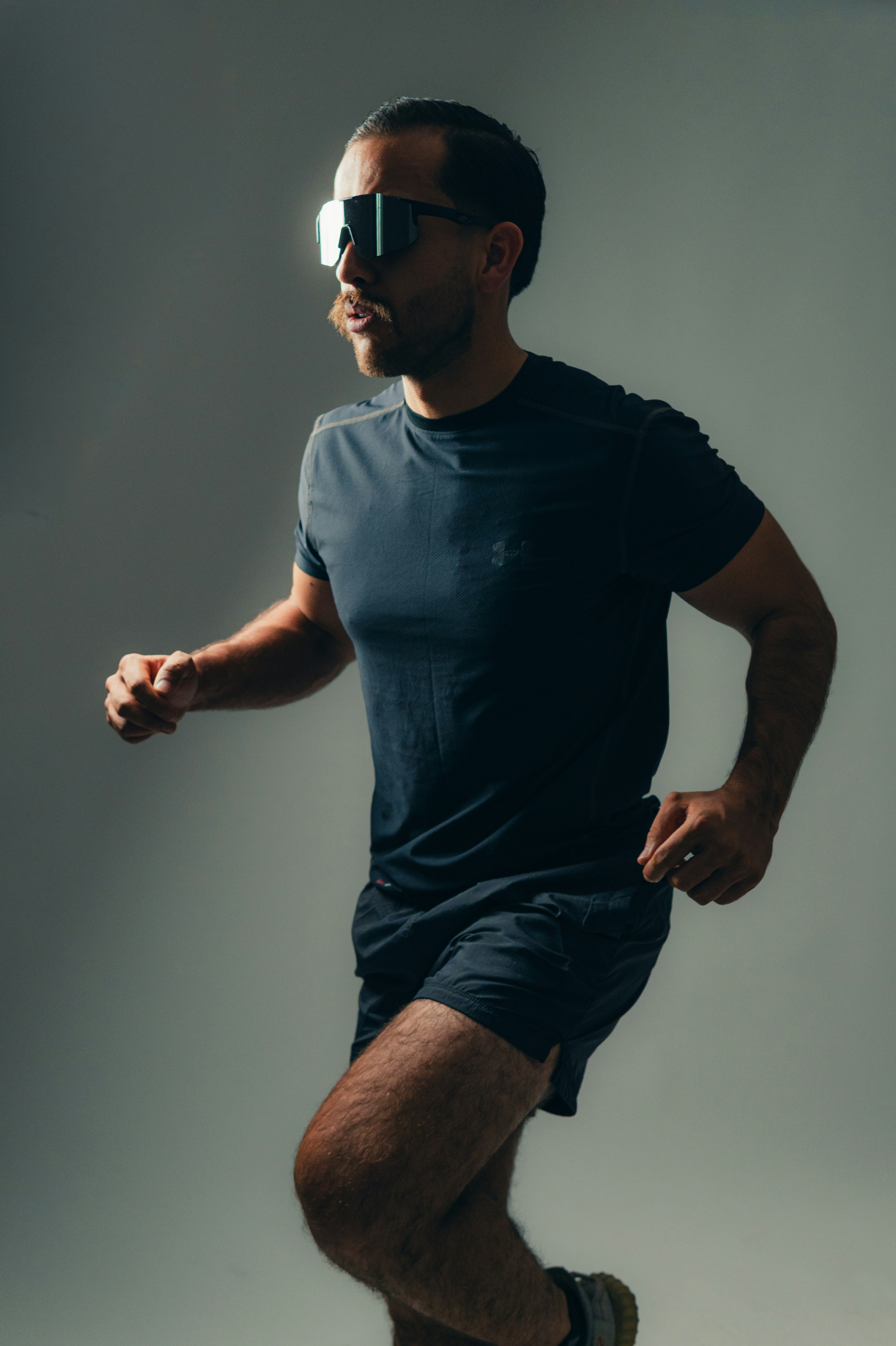 Runner poses wearing sunglasses and athletic attire.