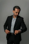 A businessman in a suit looks at his watch.
