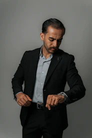 A businessman in a suit looks at his watch.
