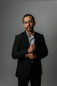 Man in a suit looks at the camera.