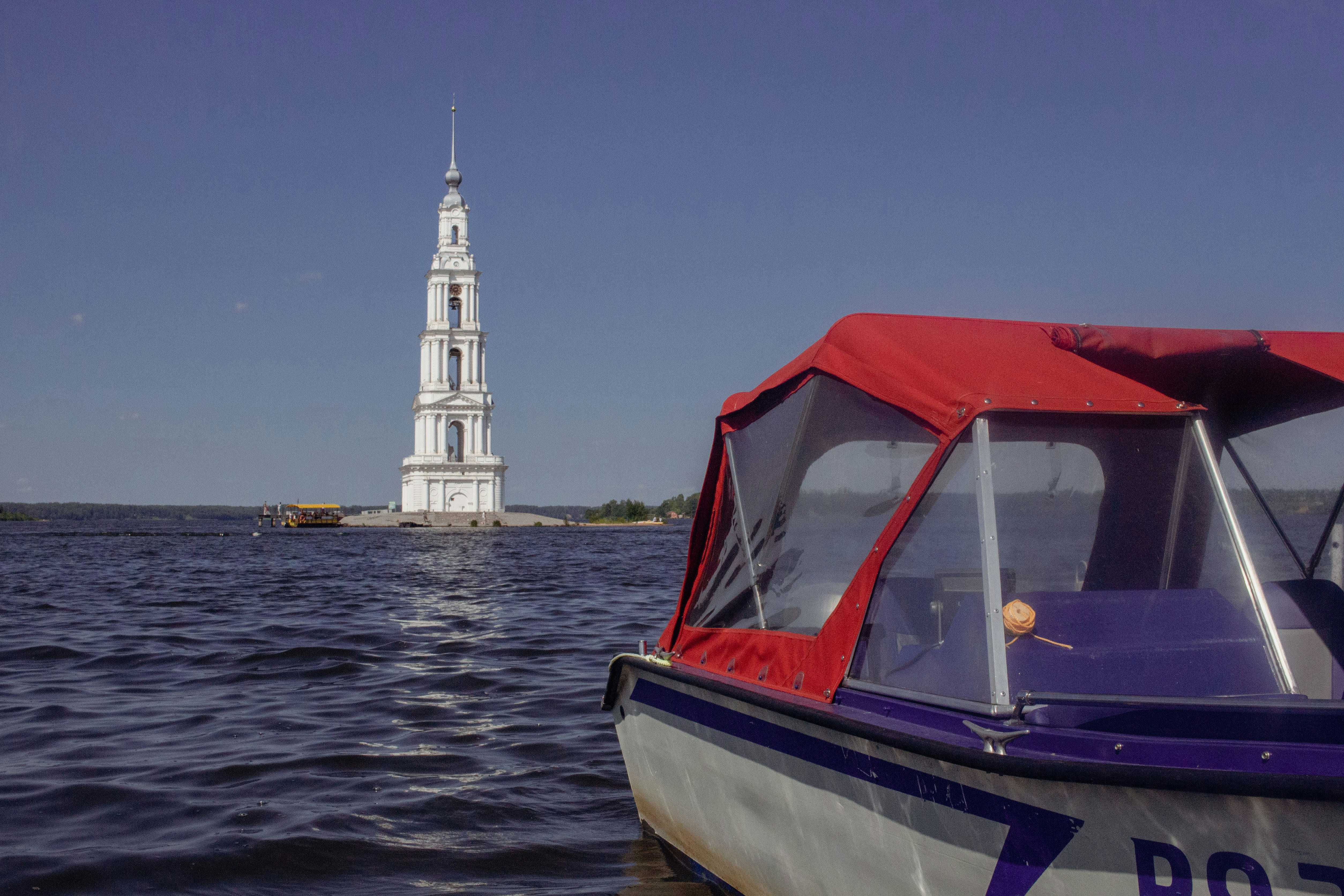 Ein Boot passiert einen überfluteten Kirchturm.