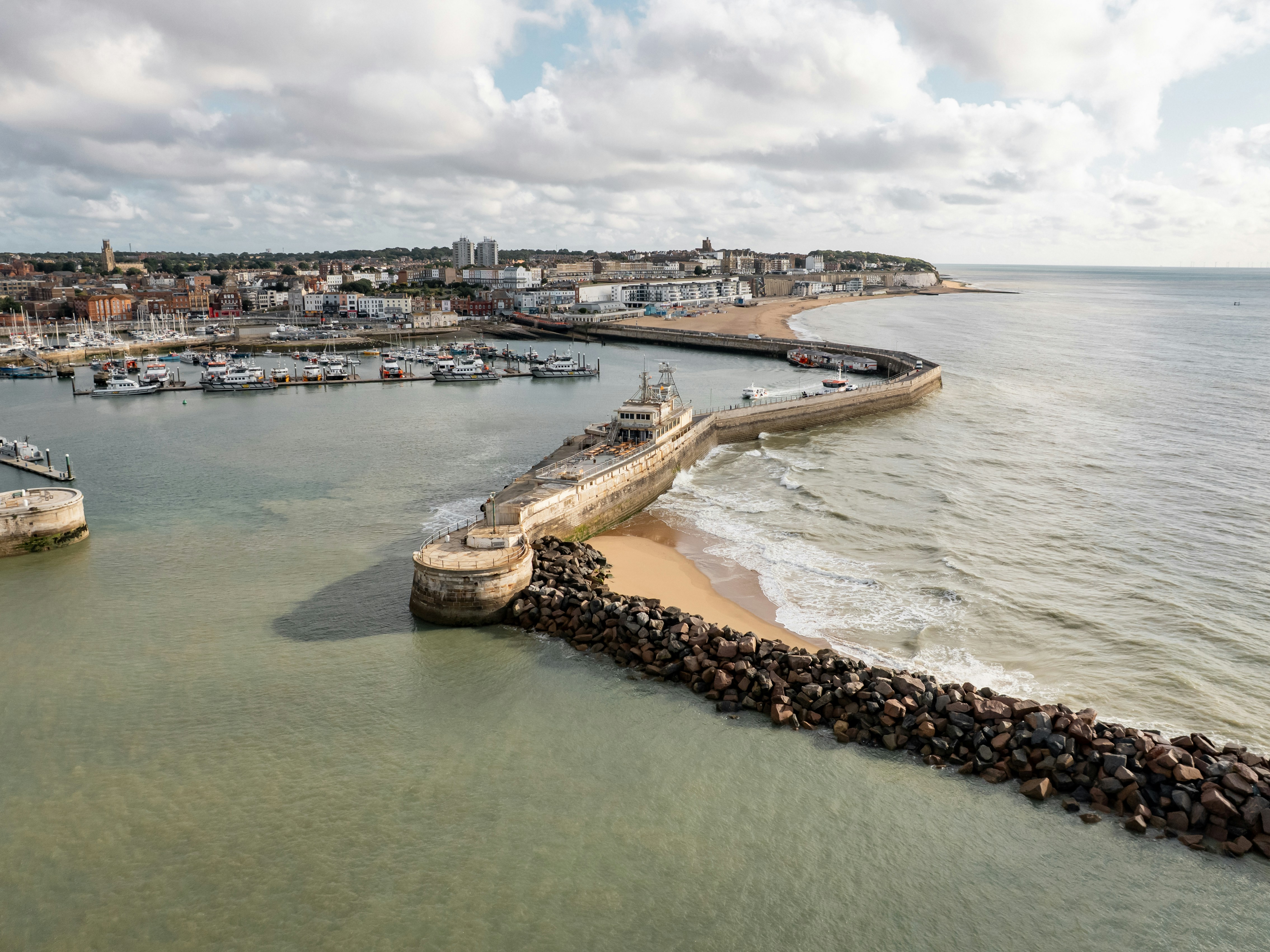 A seaside town with a harbor and breakwaters.