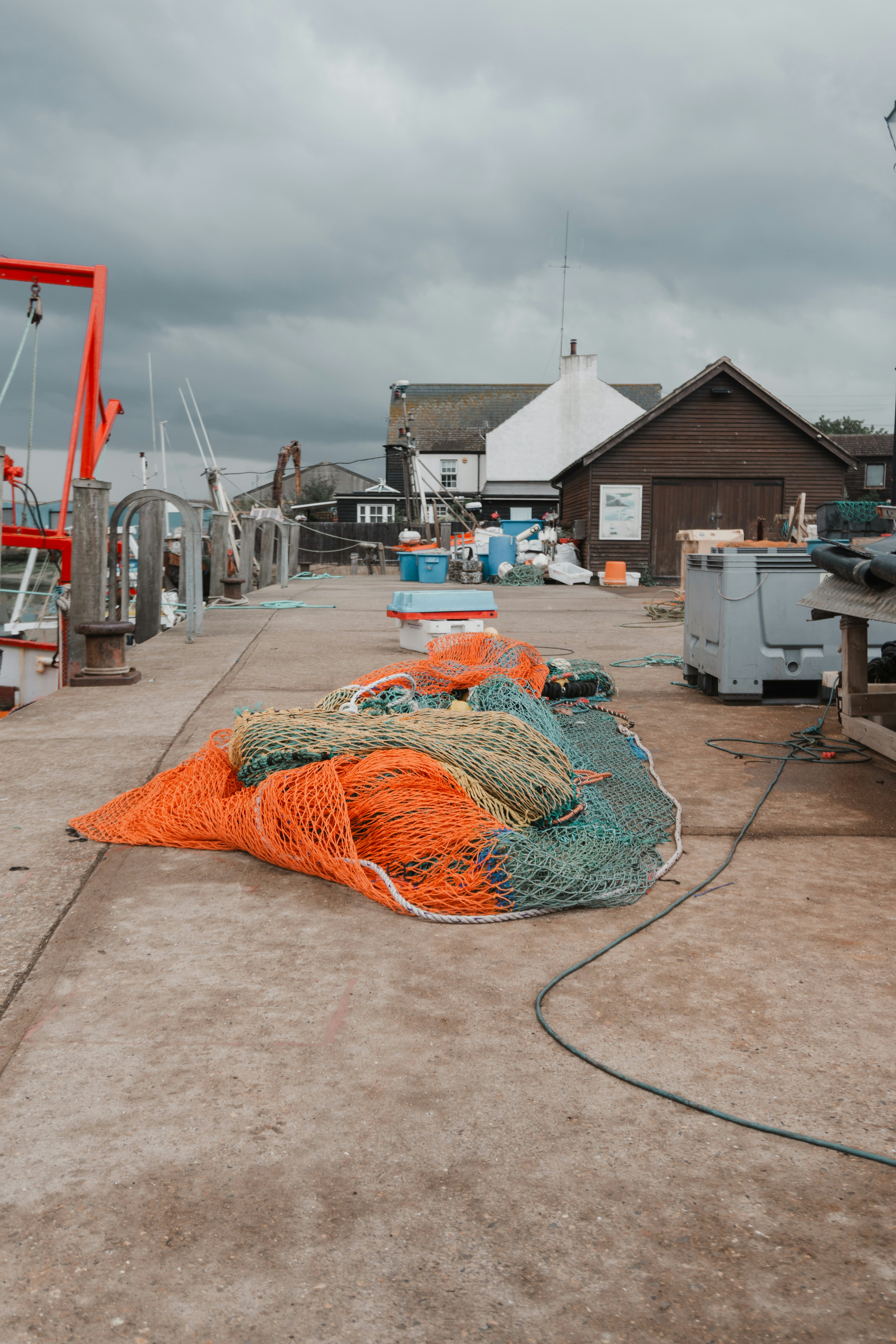 Fishing nets rest on a pier under a cloudy sky.