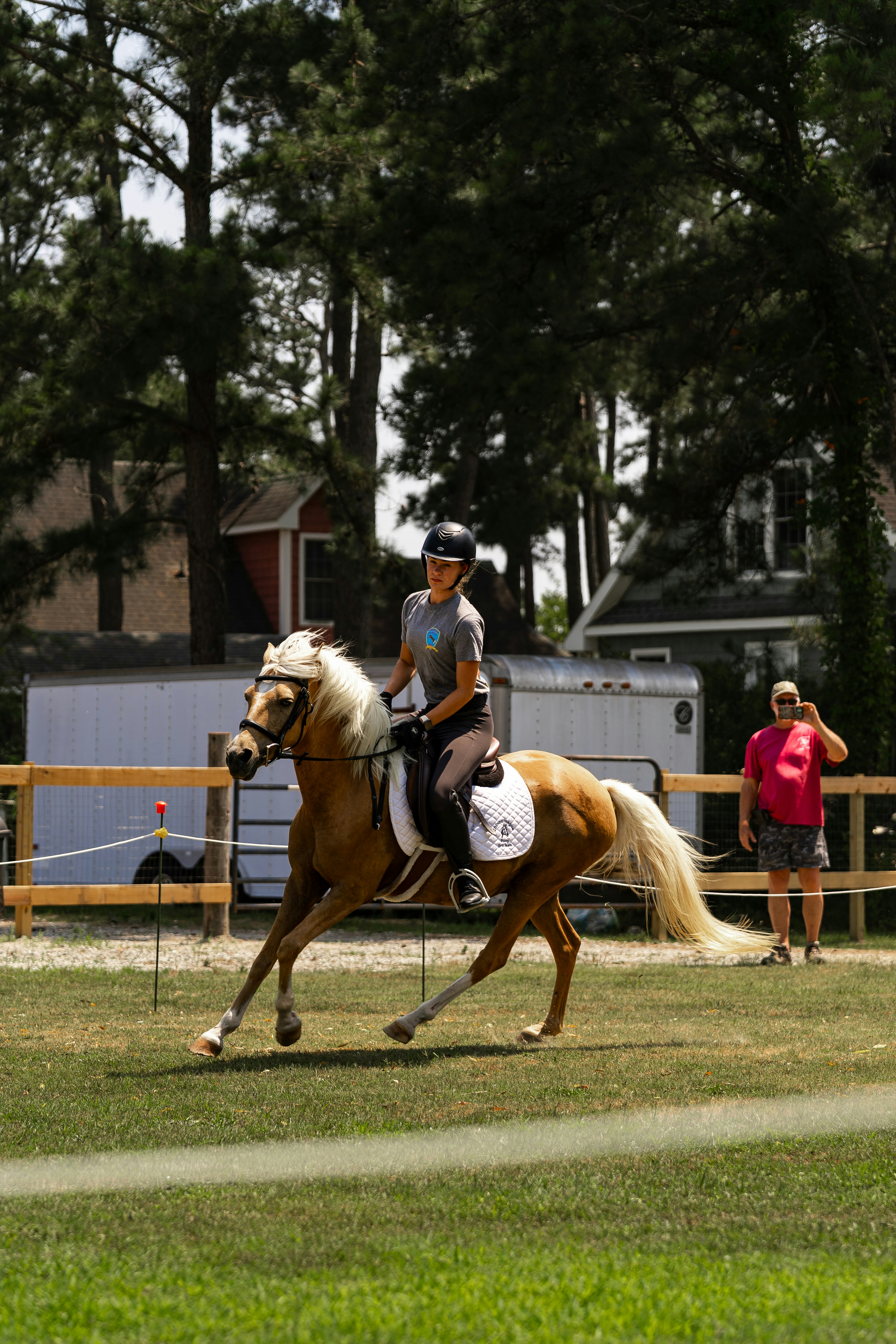 A person rides a horse in an outdoor arena.