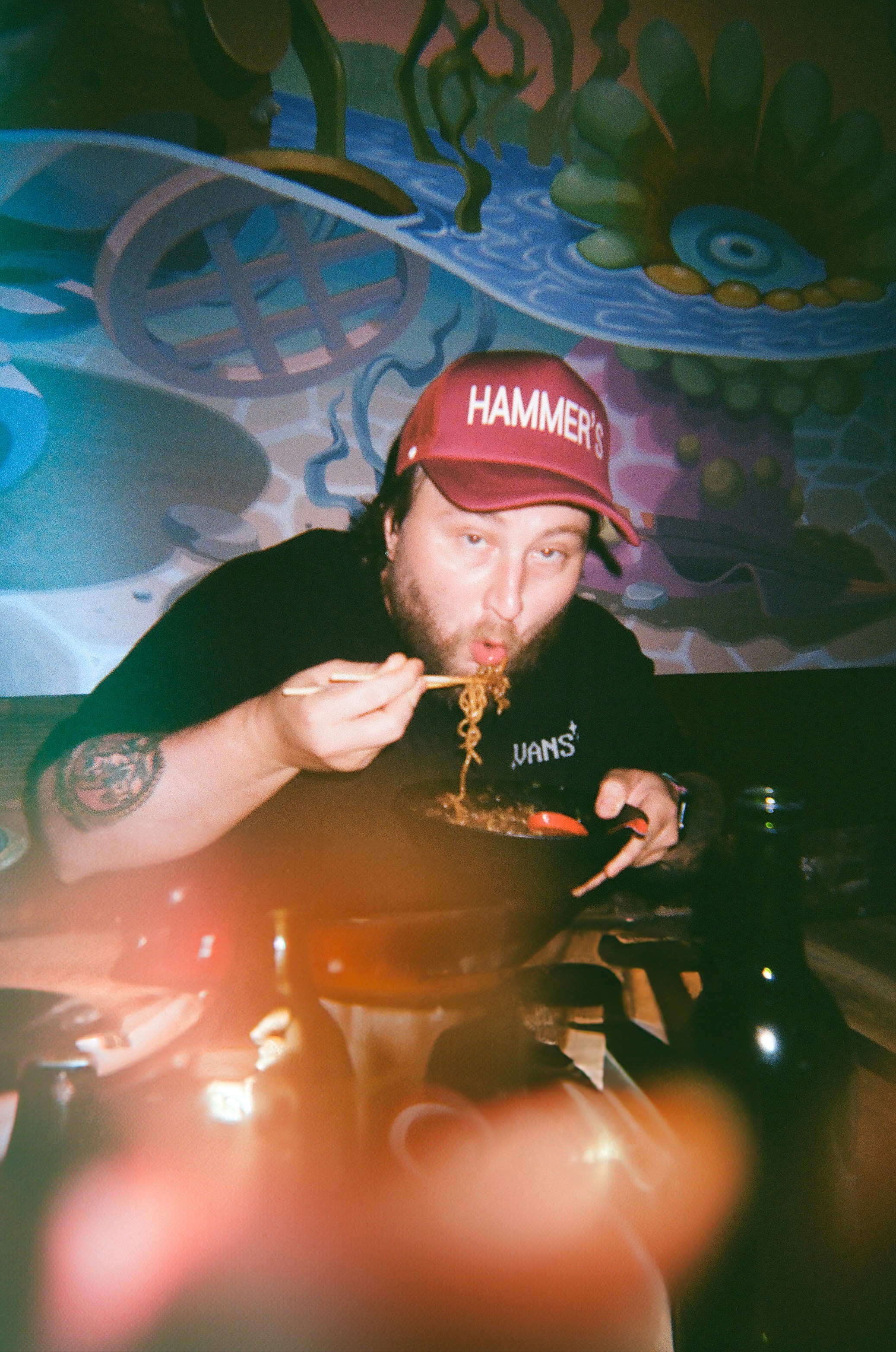 Man happily eats noodles with chopsticks.