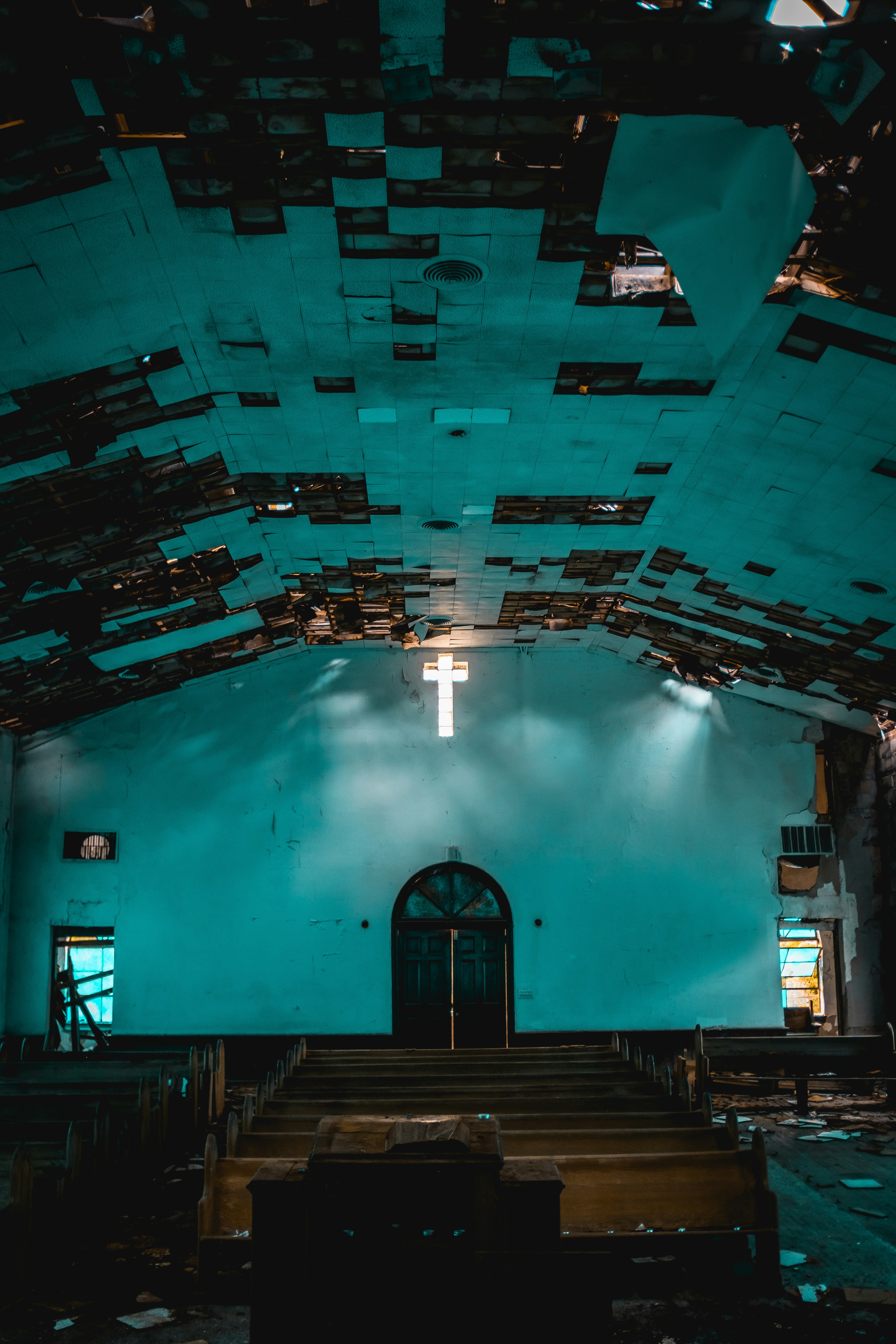 Abandoned church interior with a glowing cross.