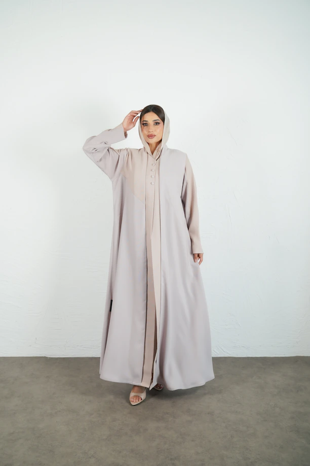 Woman wears a stylish, neutral-colored abaya.