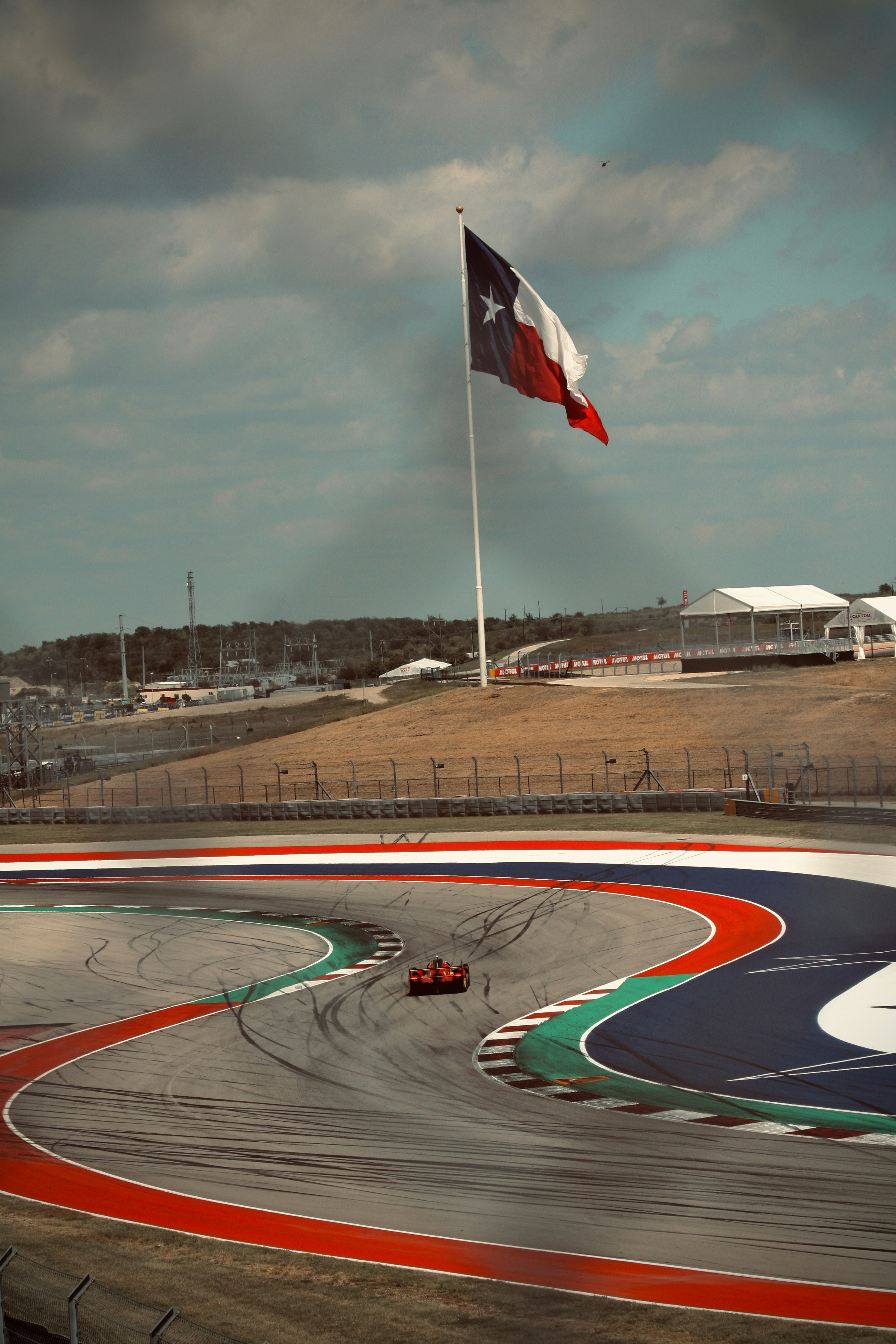 A race car speeds around the texas circuit.