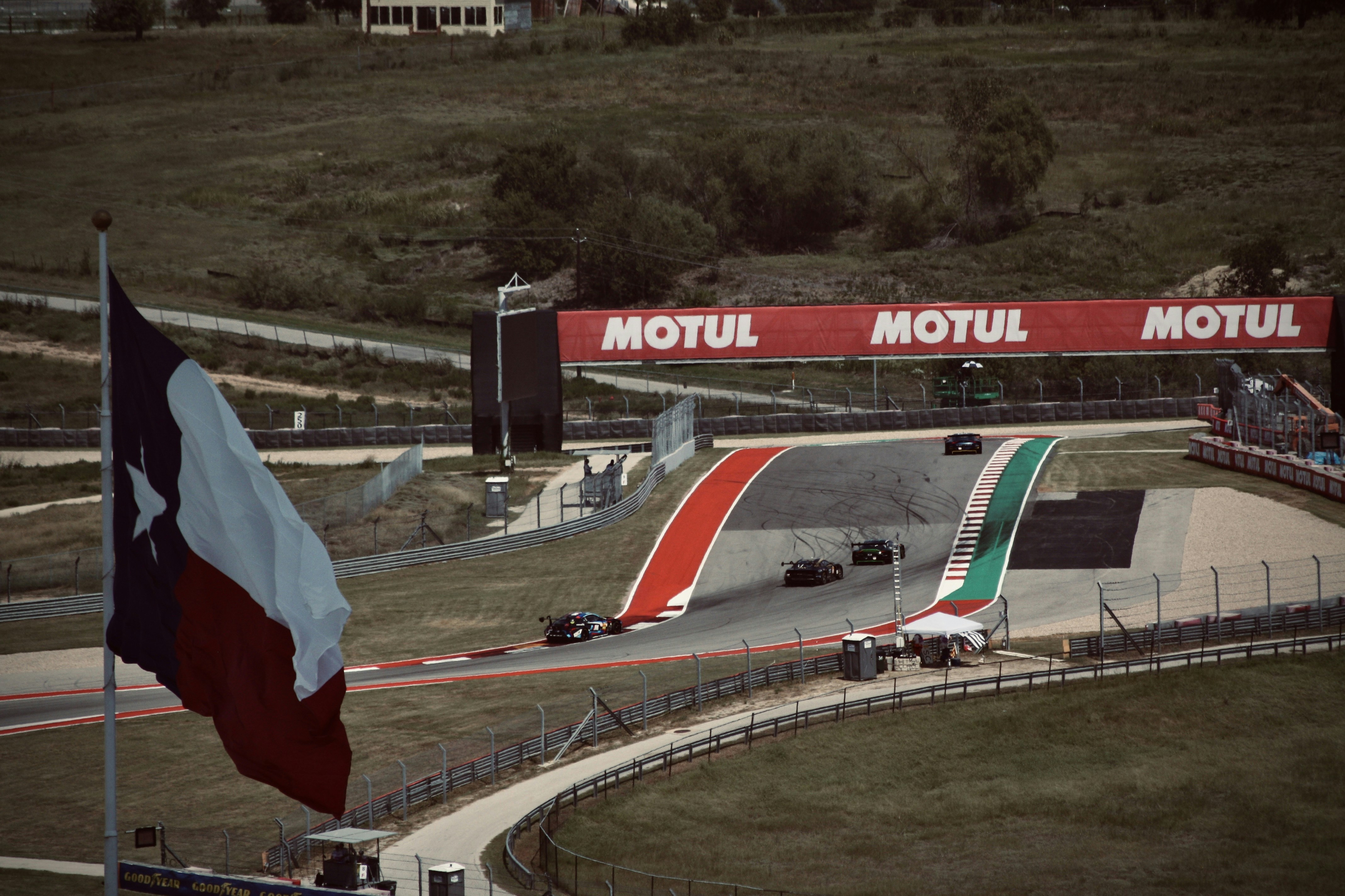 Formula 1 race cars speed along a track.