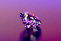 A sparkly diamond shines on a purple background.