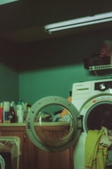 Open washing machine in a dimly lit laundry room.
