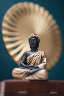 A golden buddha statue sits in quiet meditation.