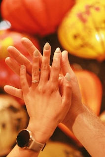 A diamond ring shines on intertwined hands.