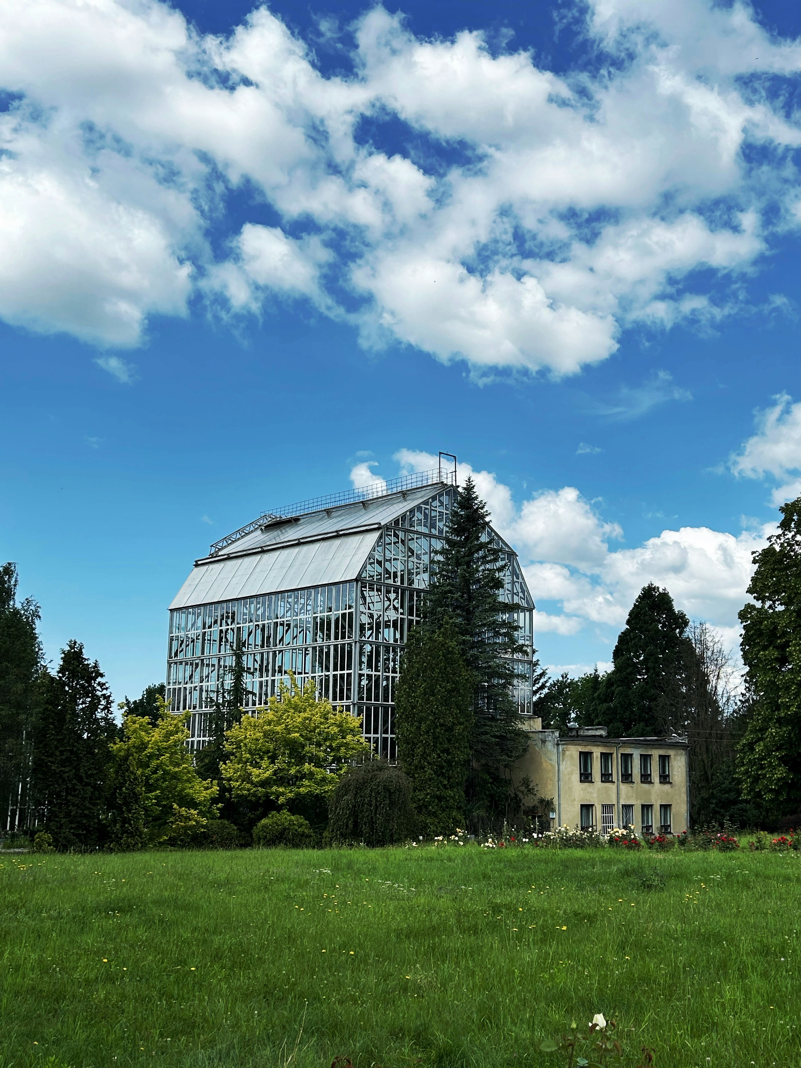 Greenhouse and buildings under a blue sky.