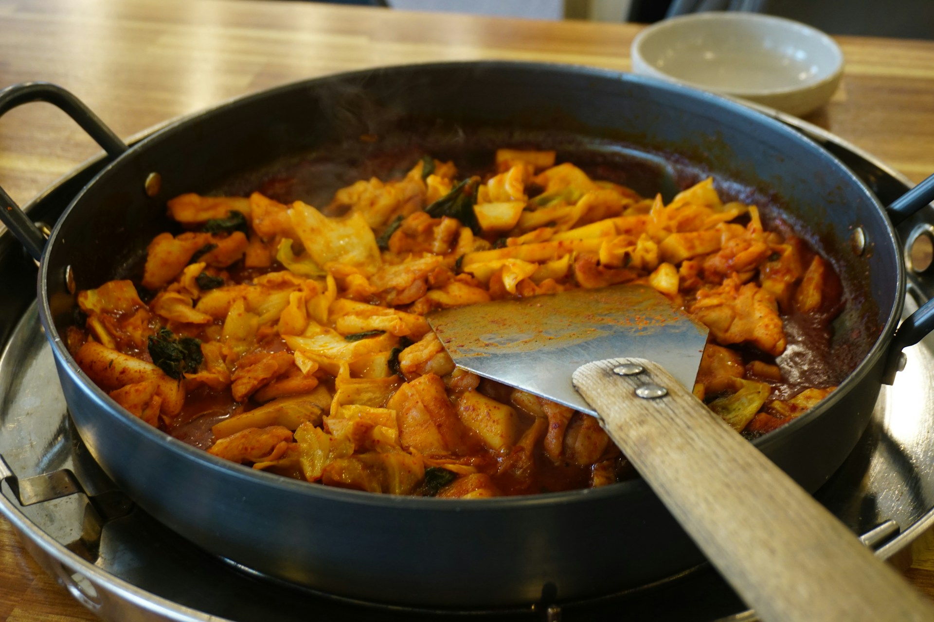 A korean dish, spicy dak-galbi, is cooking.