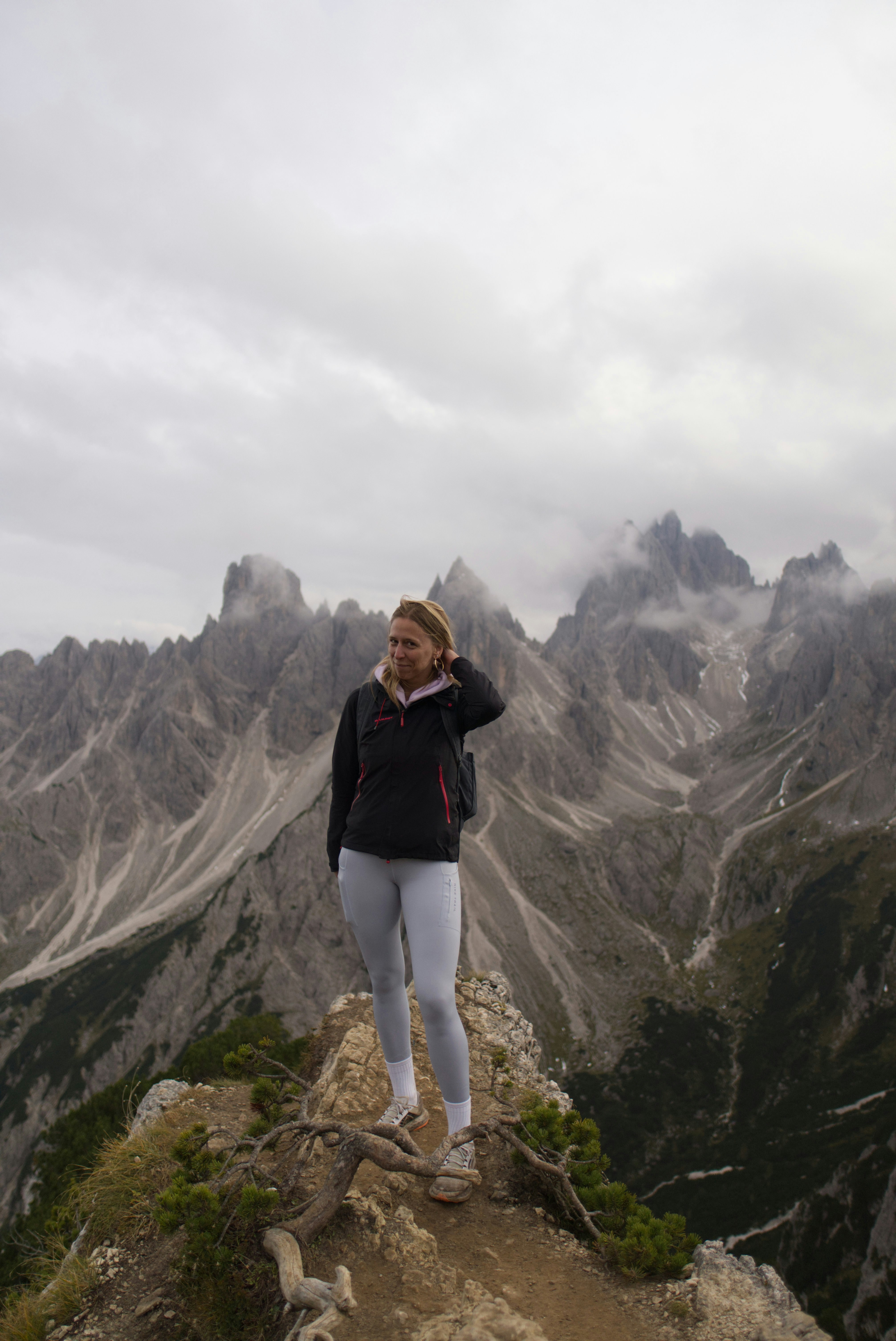 Woman stands on a mountain ridge with a beautiful view.