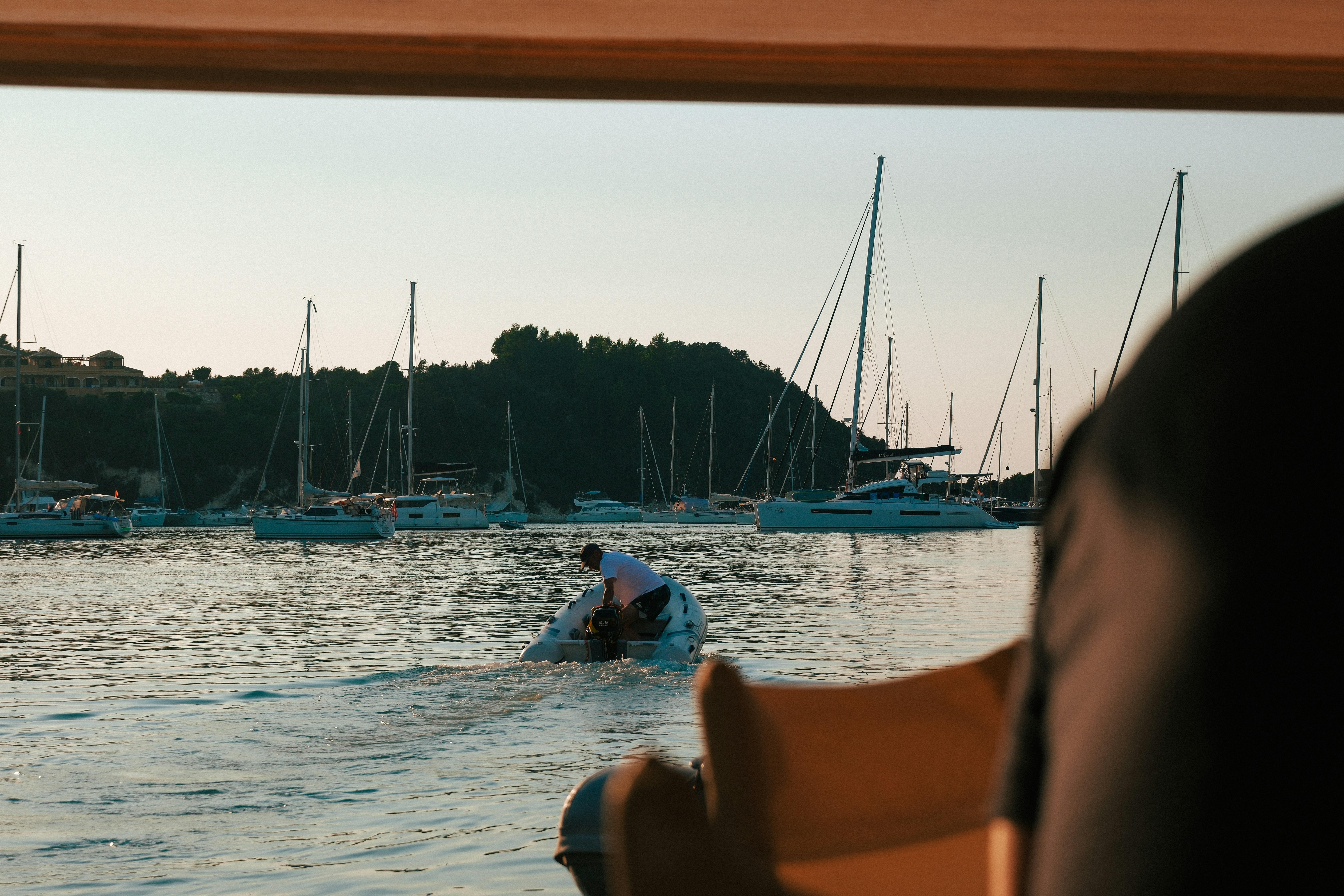 한 사람이 잔잔한 물 속에서 배를 조종하고 있습니다.