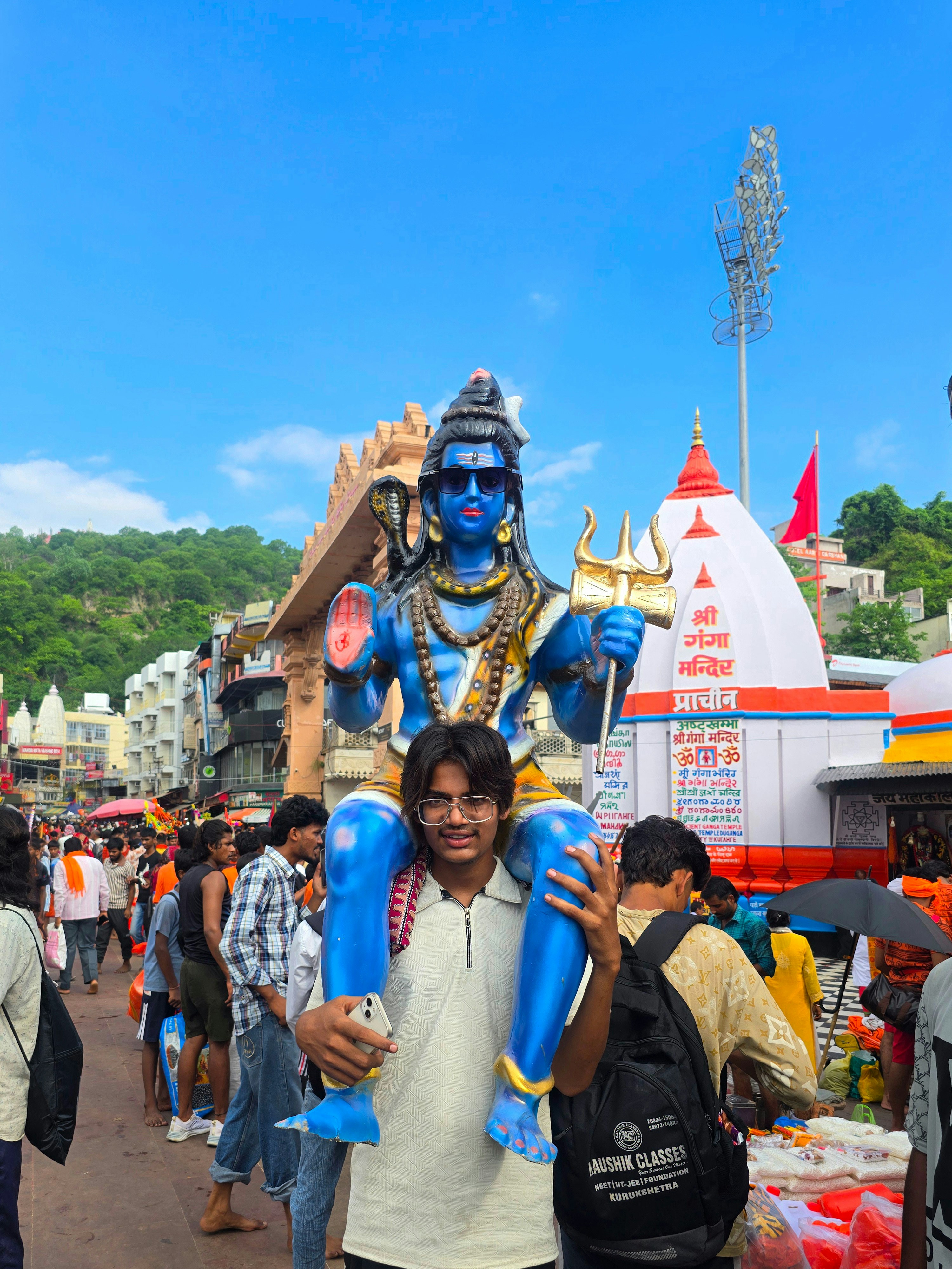 A man carries a statue of lord shiva.