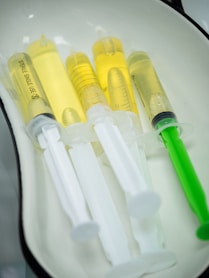 Syringes filled with yellow liquid are in a tray.