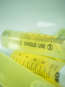 Syringes filled with yellow liquid are shown.