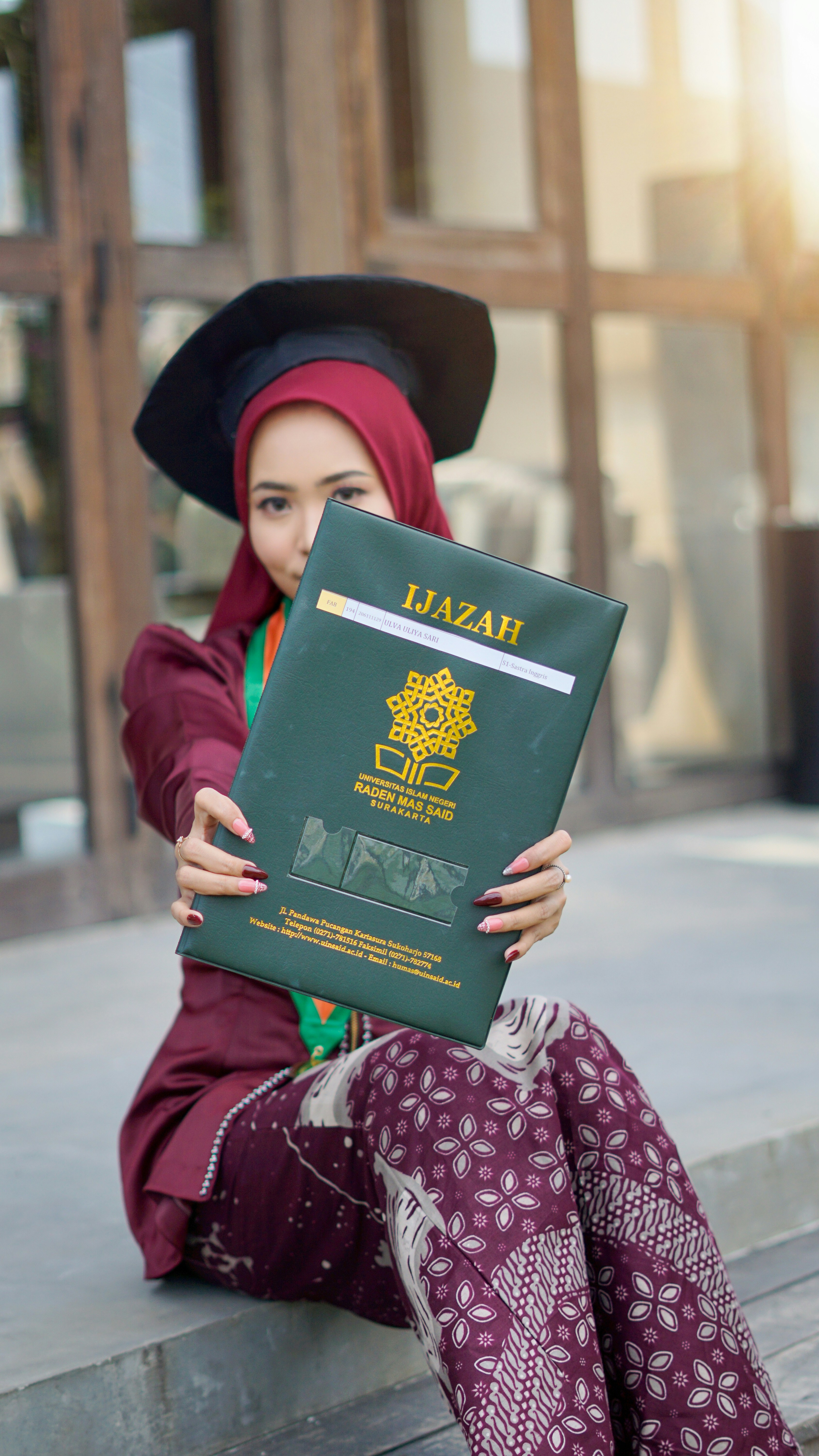 A graduate shows off her diploma, or "ijazah".