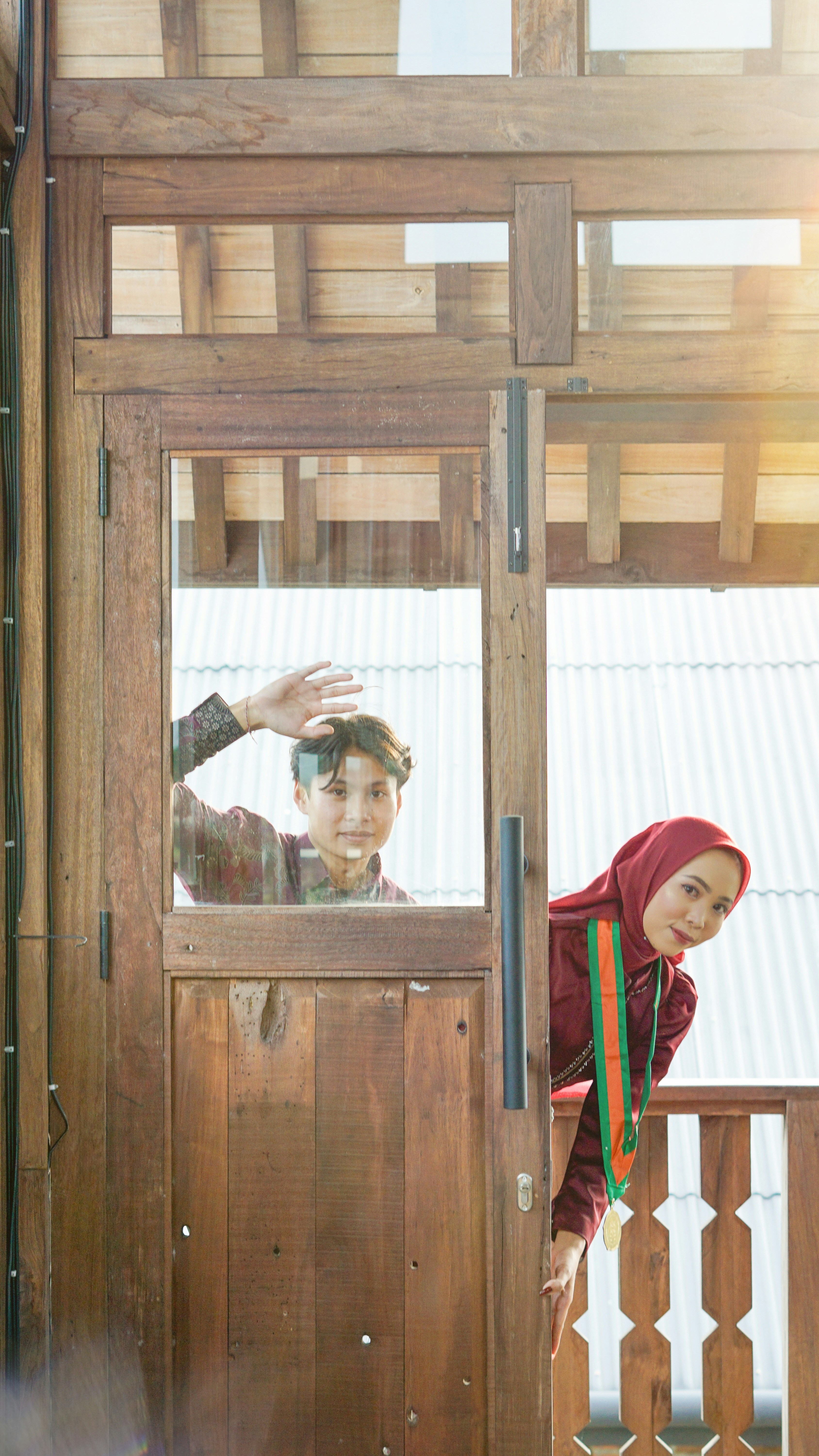Couple waves from a wooden doorway.