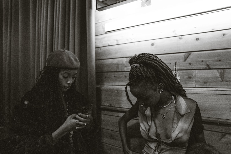 Two women sit quietly in a dim-lit room.