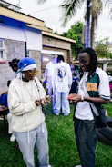 Two people are conversing at an outdoor gathering.