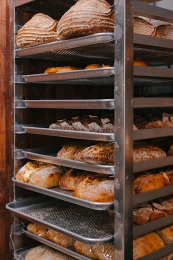 Freshly baked loaves of bread rest on a rack.