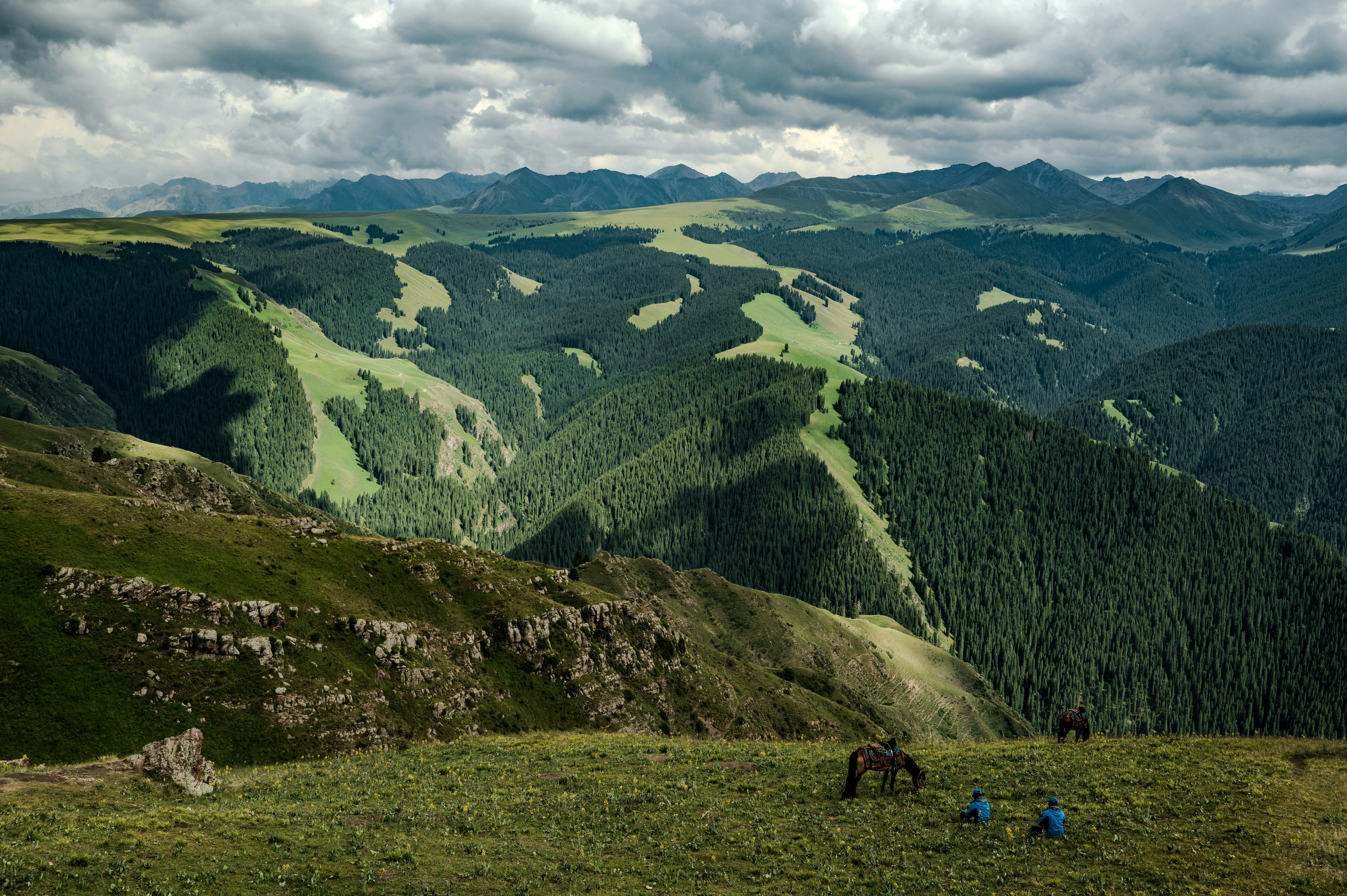 Rolling green hills and mountains under cloudy skies.