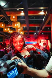 Woman smiles for a photo at a lively event.